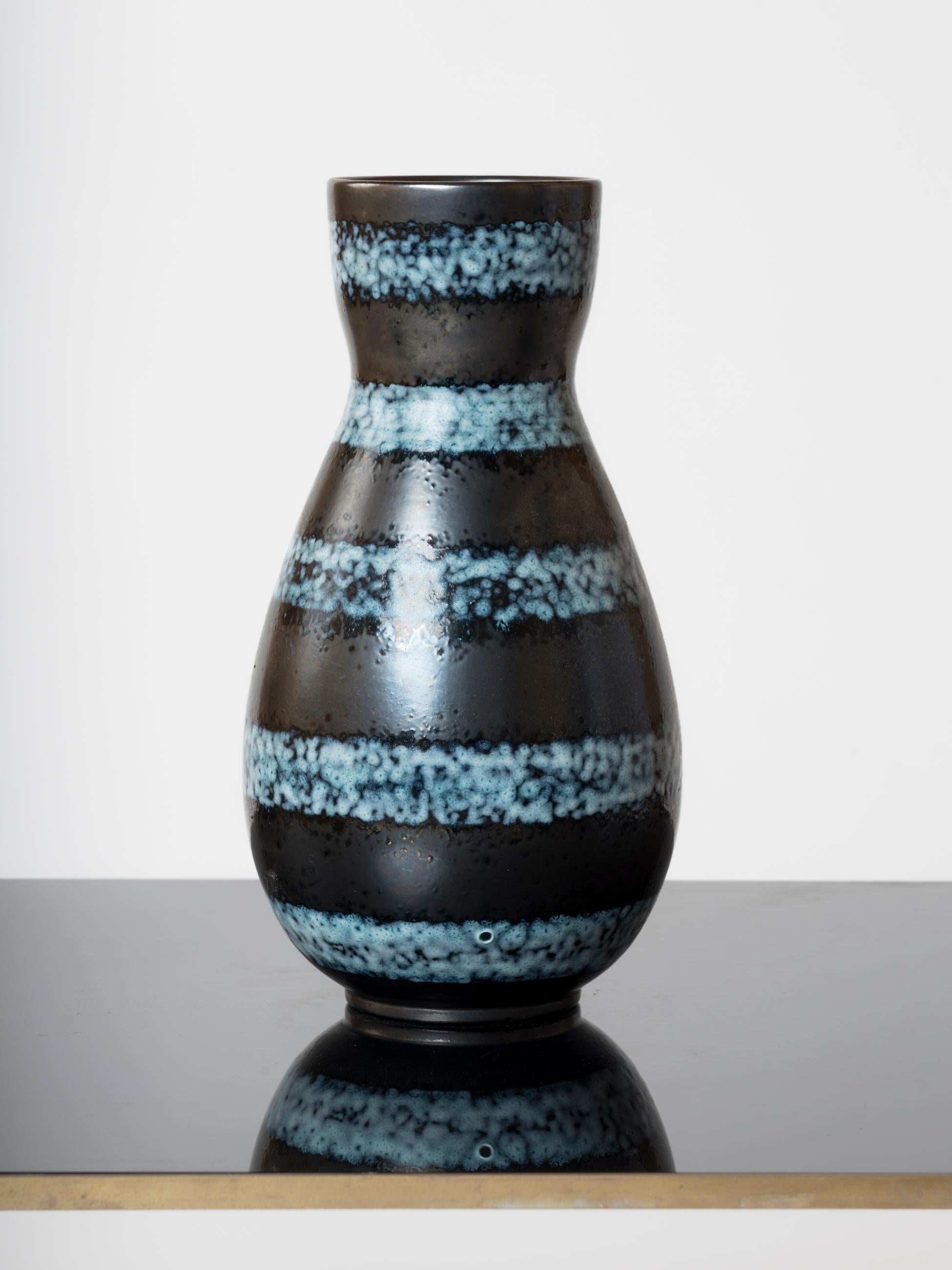 Eleganza, vaso in terracotta smaltata della fabbrica Elchinger in Alsazia, Francia.
Decorato con fregi paralleli di nebulose blu su sfondo nero.
Questo vaso viene spedito dalla Francia e può essere rispedito sia in Francia che in una struttura nel