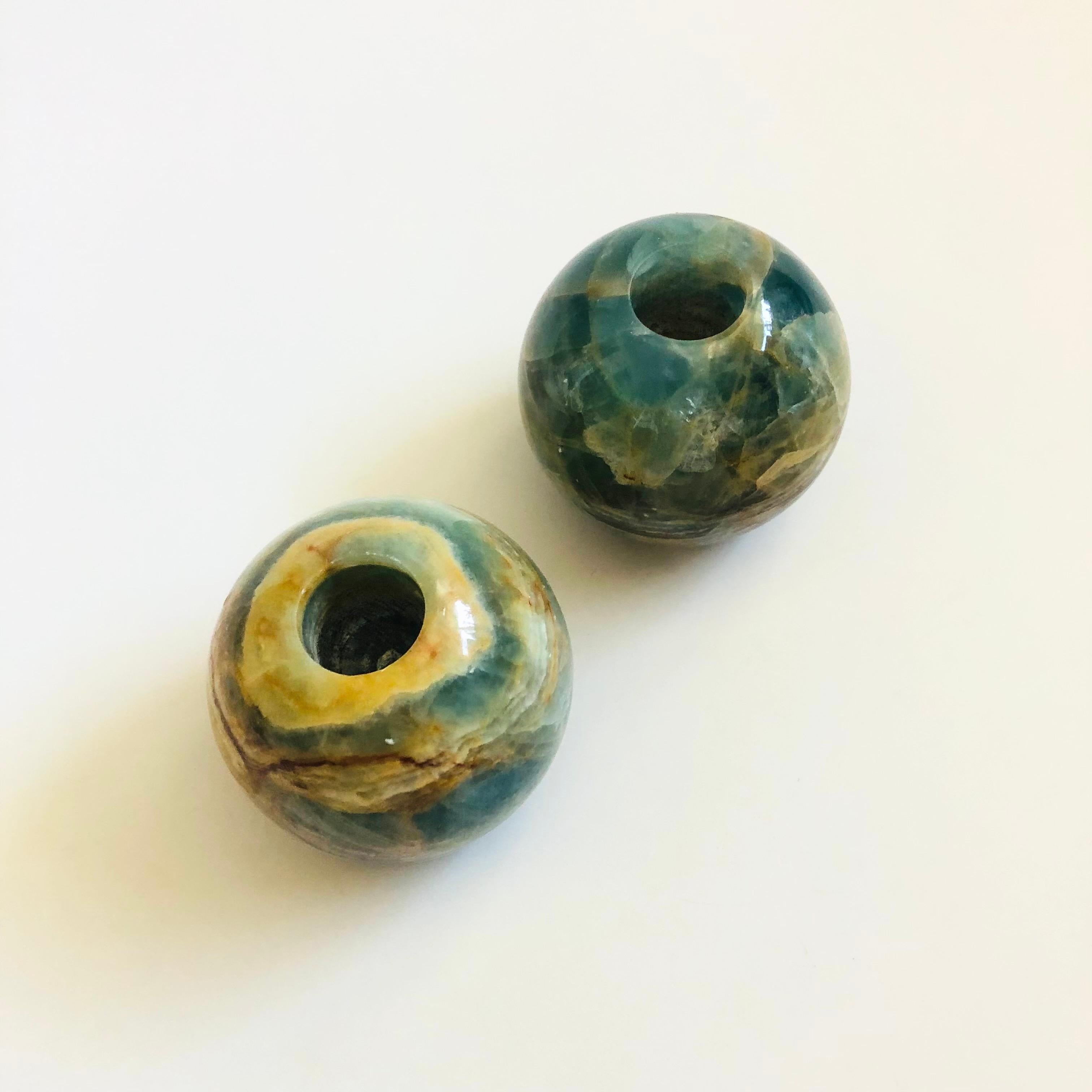A set of 2 vintage blue onyx stone candle holders. Simple sphere shapes. Beautiful blue and tan coloring and veining to the stone. Felted bottoms. Made to hold standard taper candles.

