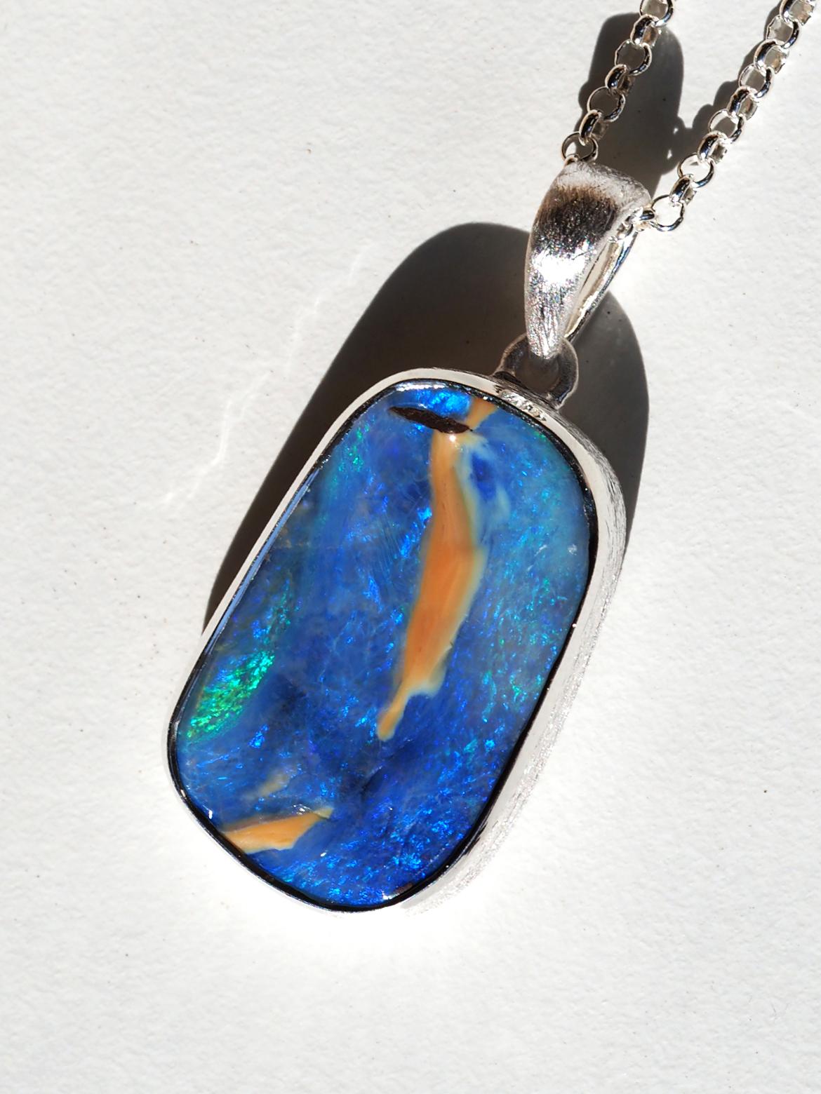 Mittelgroßer Silberanhänger mit natürlichem blauen Boulder Opal von 21ct
Opal Herkunft - Australien 
Die Größe der Edelsteine beträgt 15 x 24 mm.
Länge des Anhängers - 35 mm
Gewicht des Anhängers - 7 Gramm

Die Lieferzeit kann weltweit bis zu 30