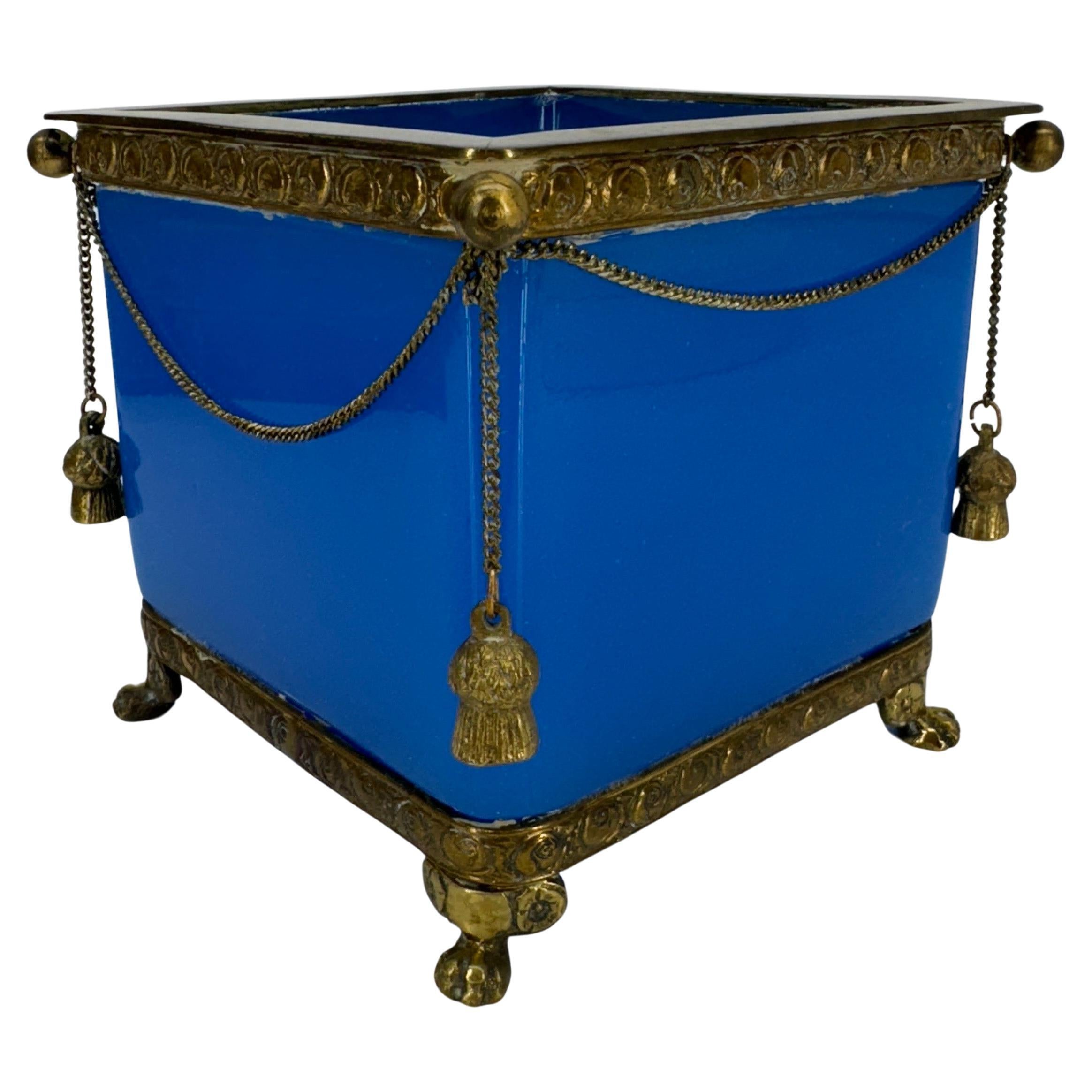 Cube shaped blue opaline glass planter jardiniere with gilt brass hardware.
The gilt brass is presented in its authentic patina but can be polished upon buyers request. All 4 corners have the brass balls.