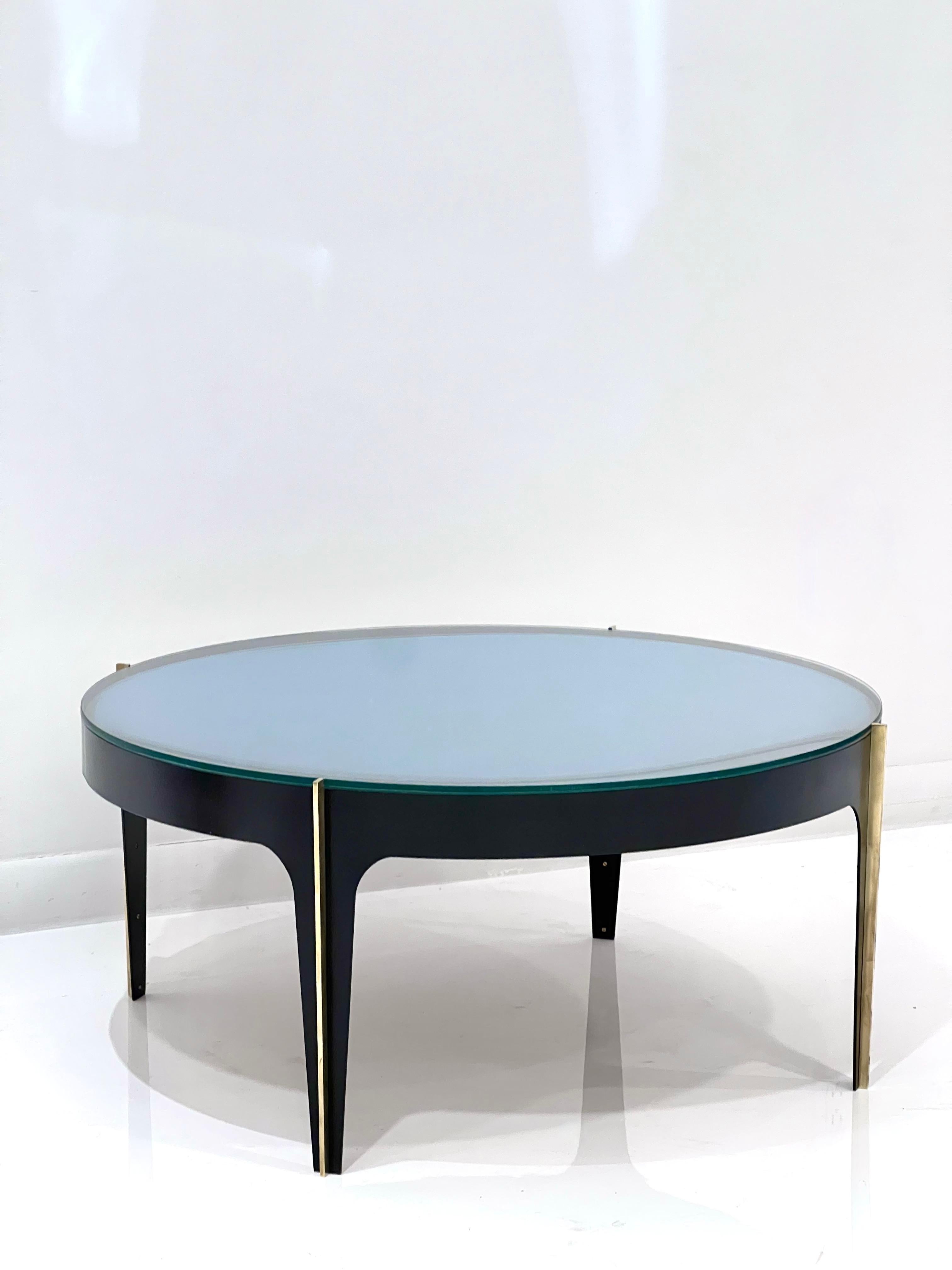 Blue Optical Glass Round Cocktail Table in the style of Max Ingrand for Fontana Arte with black enamel metal and brass accents. It features a clear class top with blue optical concave sub-mirror.