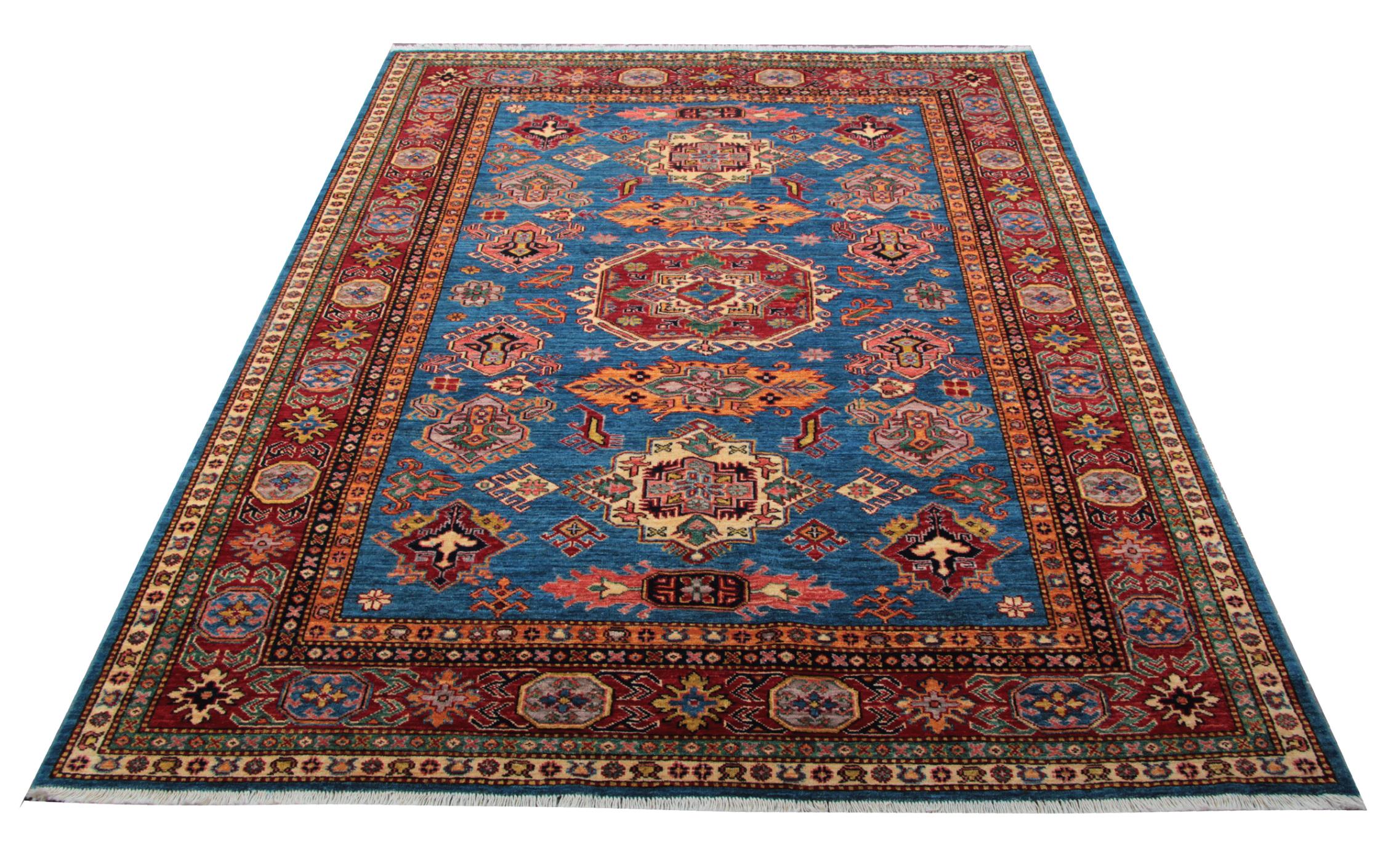 A beautiful new traditional Afghan Kazak rug, featuring a traditional tribal medallion design woven in accents of red, orange, and cream, through the center on an aqua blue field. The geometric rug design is then finished with a highly-detailed