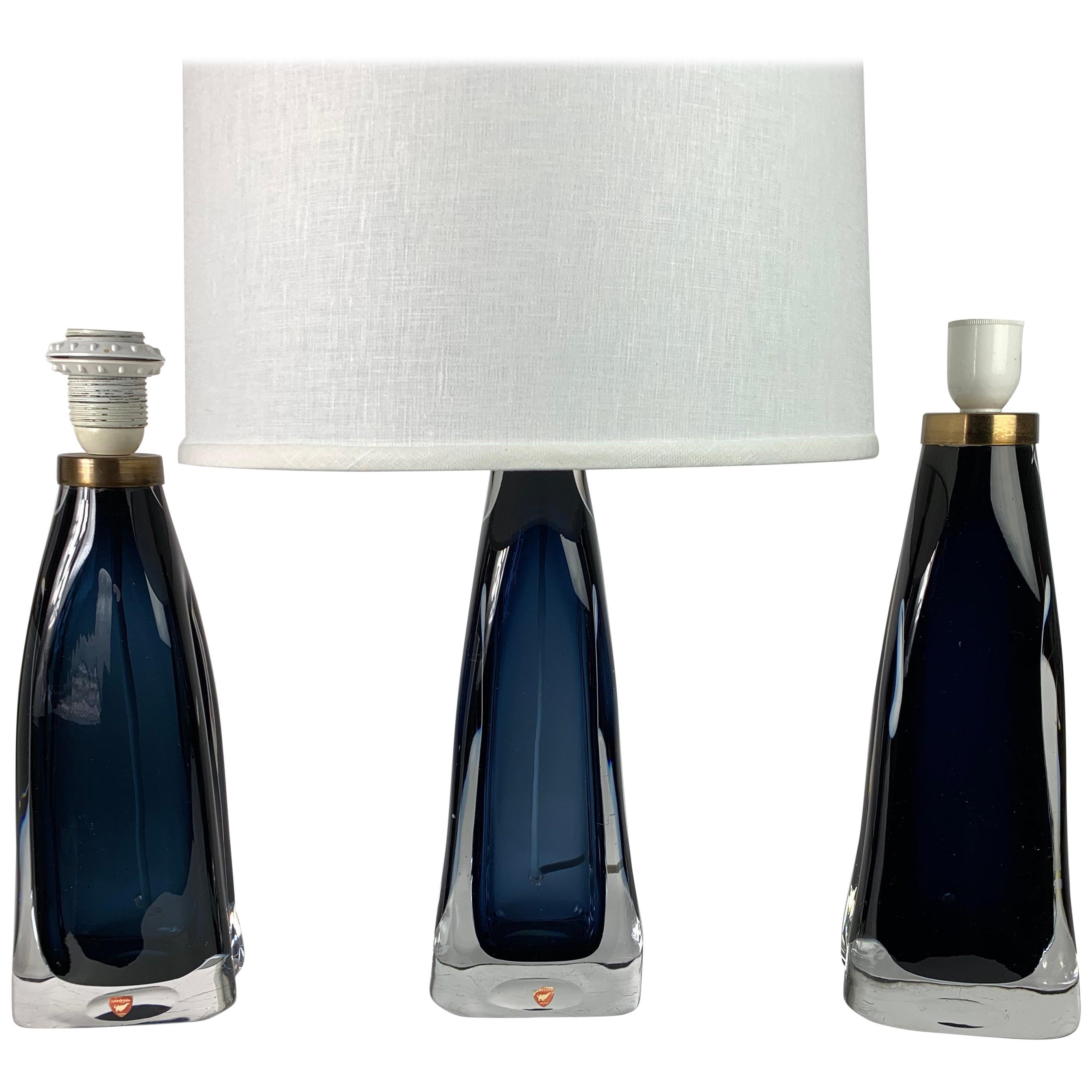 Three single lamps ranging from light blue to gray the third one is navy blue, Brass fittings by Carl Fagerlund for Orrefors, 1960, Sweden.

Shades not included.