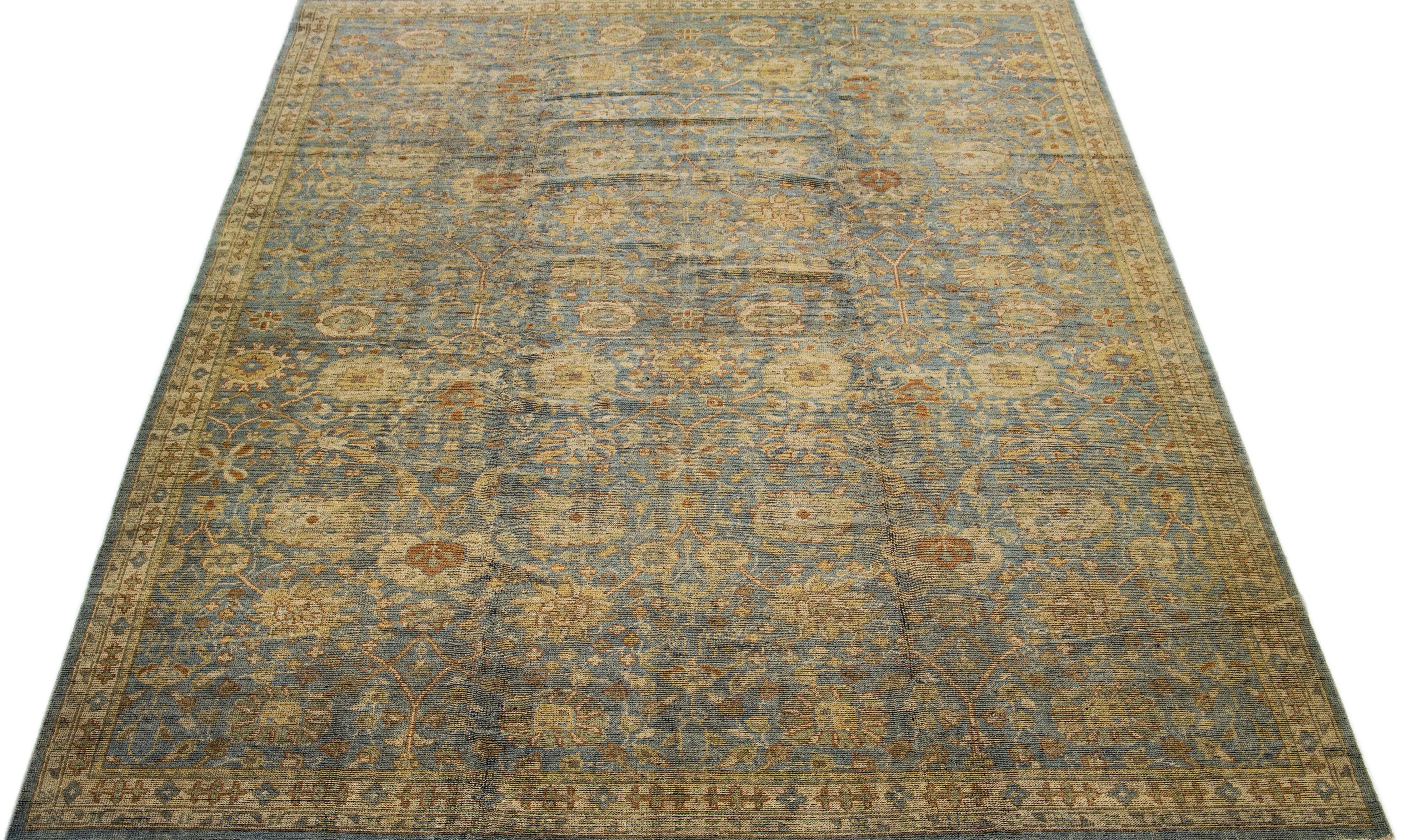 Beautiful contemporary Oushak hand knotted wool rug with a blue field. This Oushak rug has a scattered golden spray of vine scroll designed frame and an all-over geometric floral design. 

This rug measures 9'9
