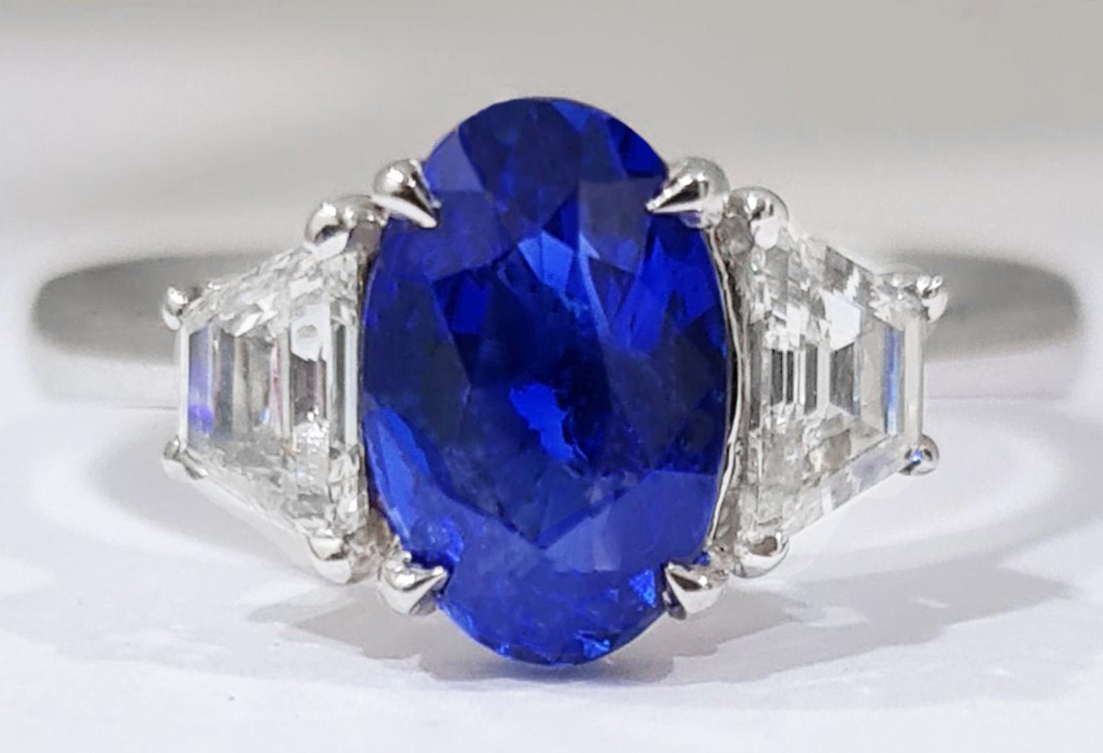 Contemporary Blue Oval 2 Carat Sapphire Ring with Side Diamonds 18k Gold For Sale