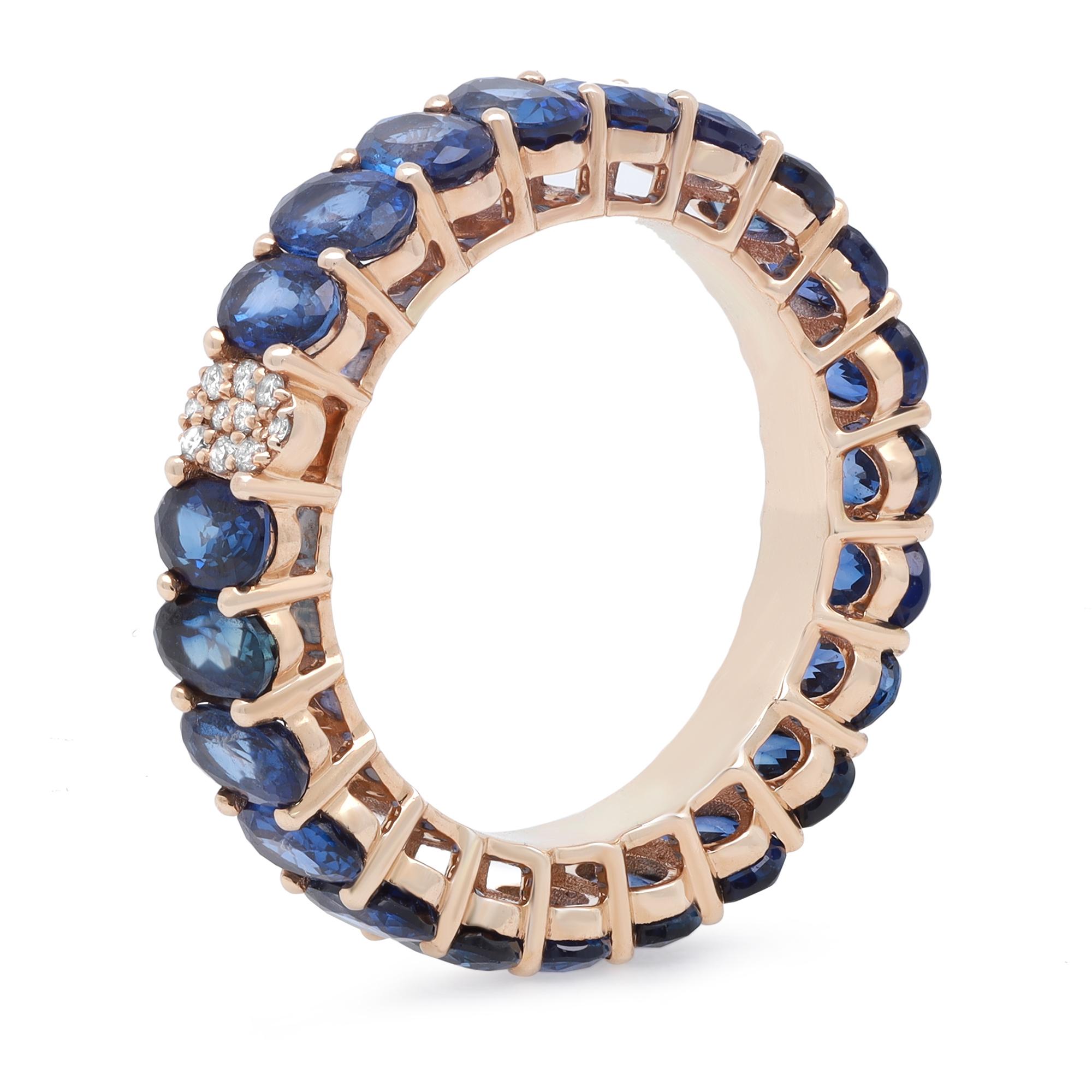 This beautiful eternity band features a pave set oval shank in the center with round cut diamonds and prong set oval cut Blue Sapphires beautifully circling all the way around the band. Crafted in fine 14k yellow gold. Blue Sapphire total carat