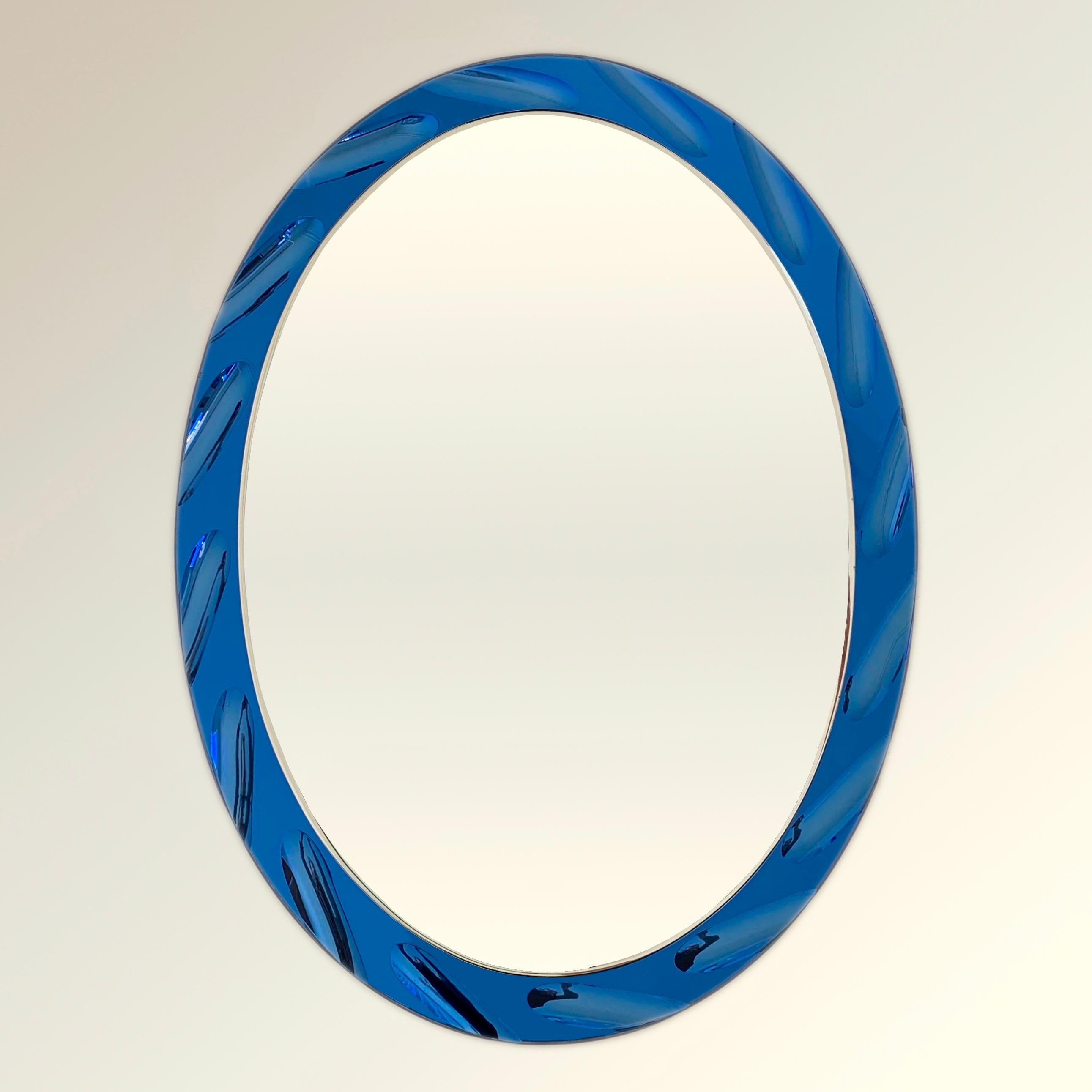 Schöner ovaler Spiegel von Cristal Arte, um 1960, Italien.
Blauer Spiegelglasrahmen mit ovalen Formen, die in den Hohlraum gezeichnet sind.
Abmessungen: 81 cm H, 61 cm B, 2 cm T.
Guter Originalzustand.
Alle Käufe sind durch unsere