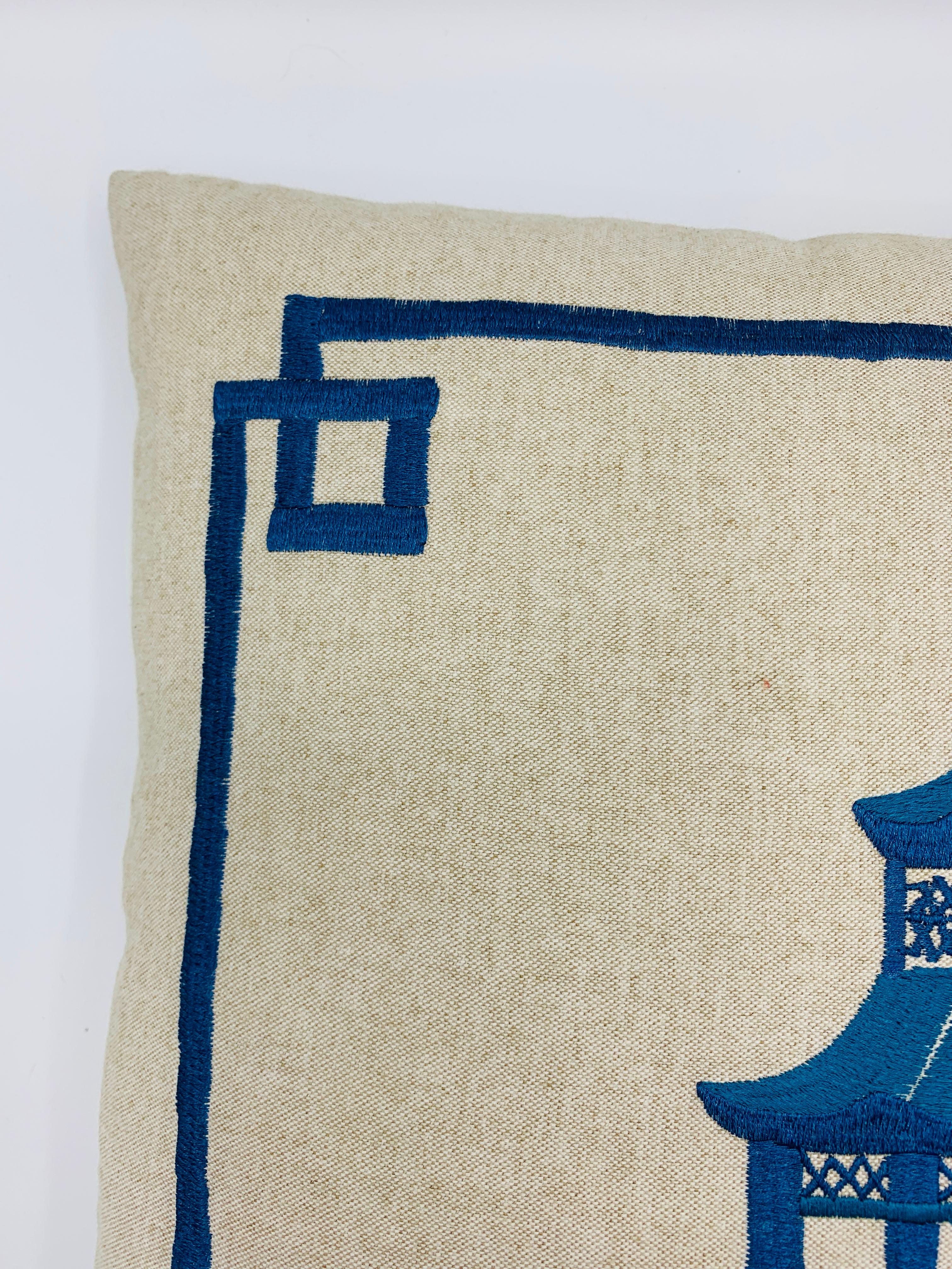 Listed is a stunning, custom chinoiserie decorative pillow. The piece has a large, heavily detailed, two-tone blue/teal Pagoda motif embroidery with a modern fretwork embroidery along the border. Linen-cotton blend. Zipper closure. Includes down