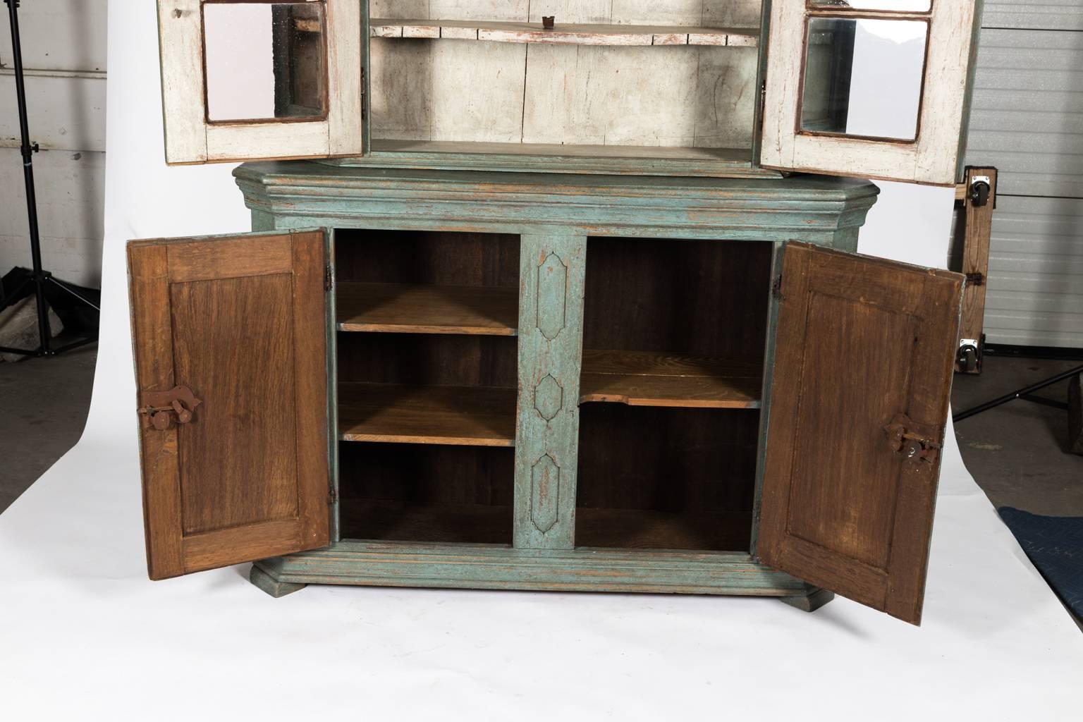 Blue painted oak display cabinet with glass fronted doors and sides, circa early 20th century. The lower part features two doors and geometric molding in an antiqued finish.
 