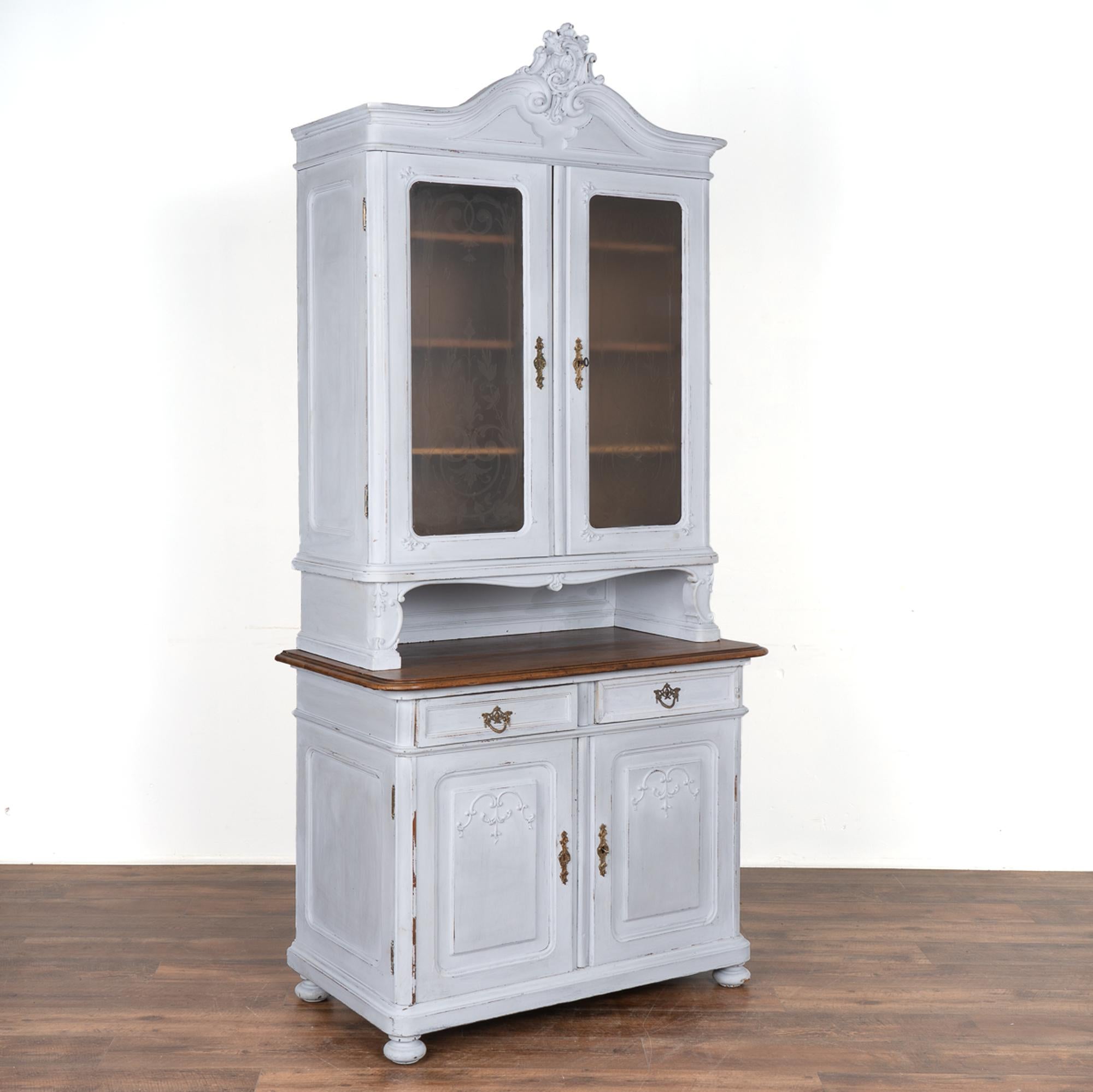 This European country pine cupboard may be used as a small buffet, display cabinet or even bookcase. The original etched glass accents the decorative applied carving that accents the panels of this charming cabinet.
The newer professionally applied