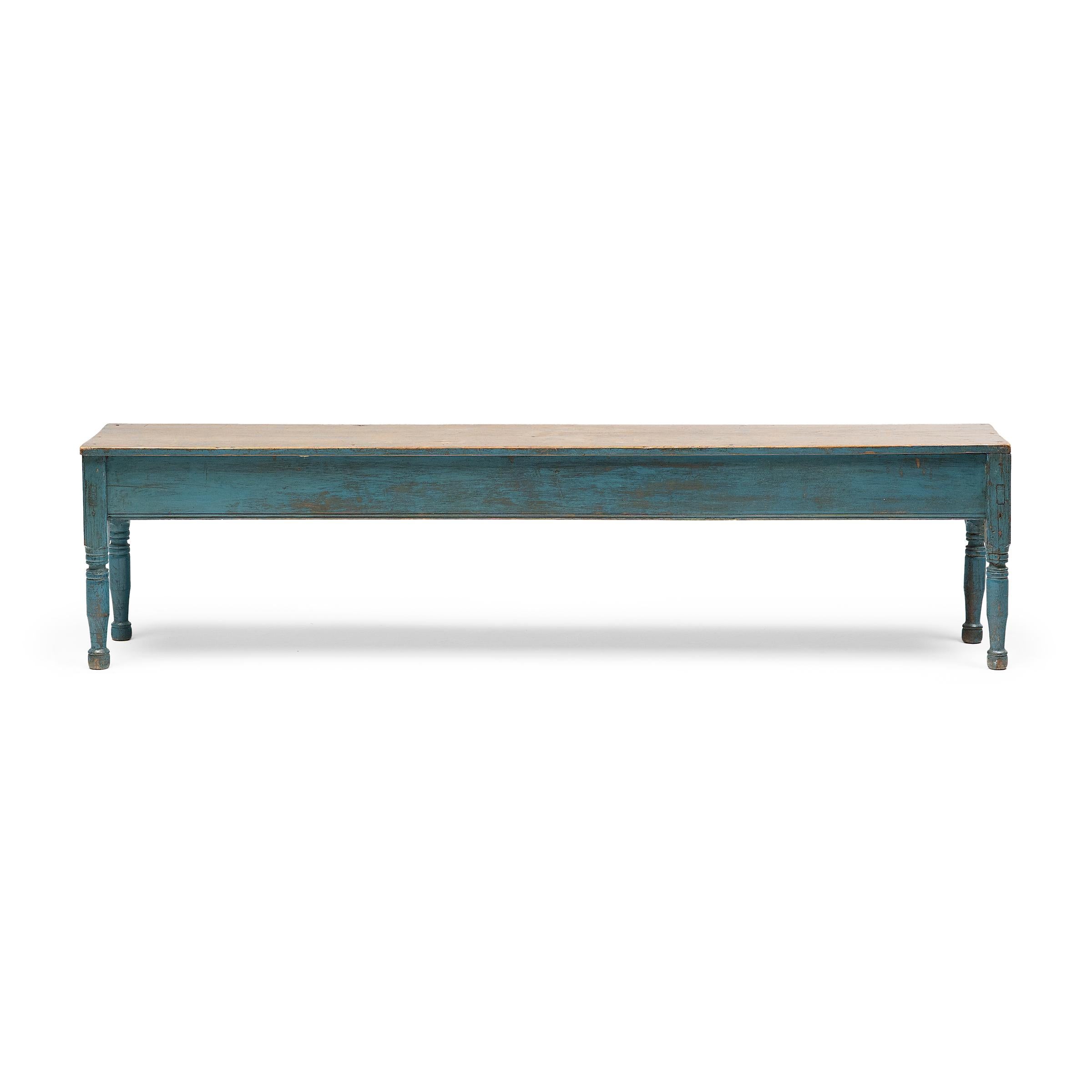 The painted exterior of this provincial farmhouse bench has weathered gradually from years of use to achieve the ultimate rustic finish. Once a vibrant, robin’s egg blue, the milk paint has softened with time to a subdued color and well-worn finish,