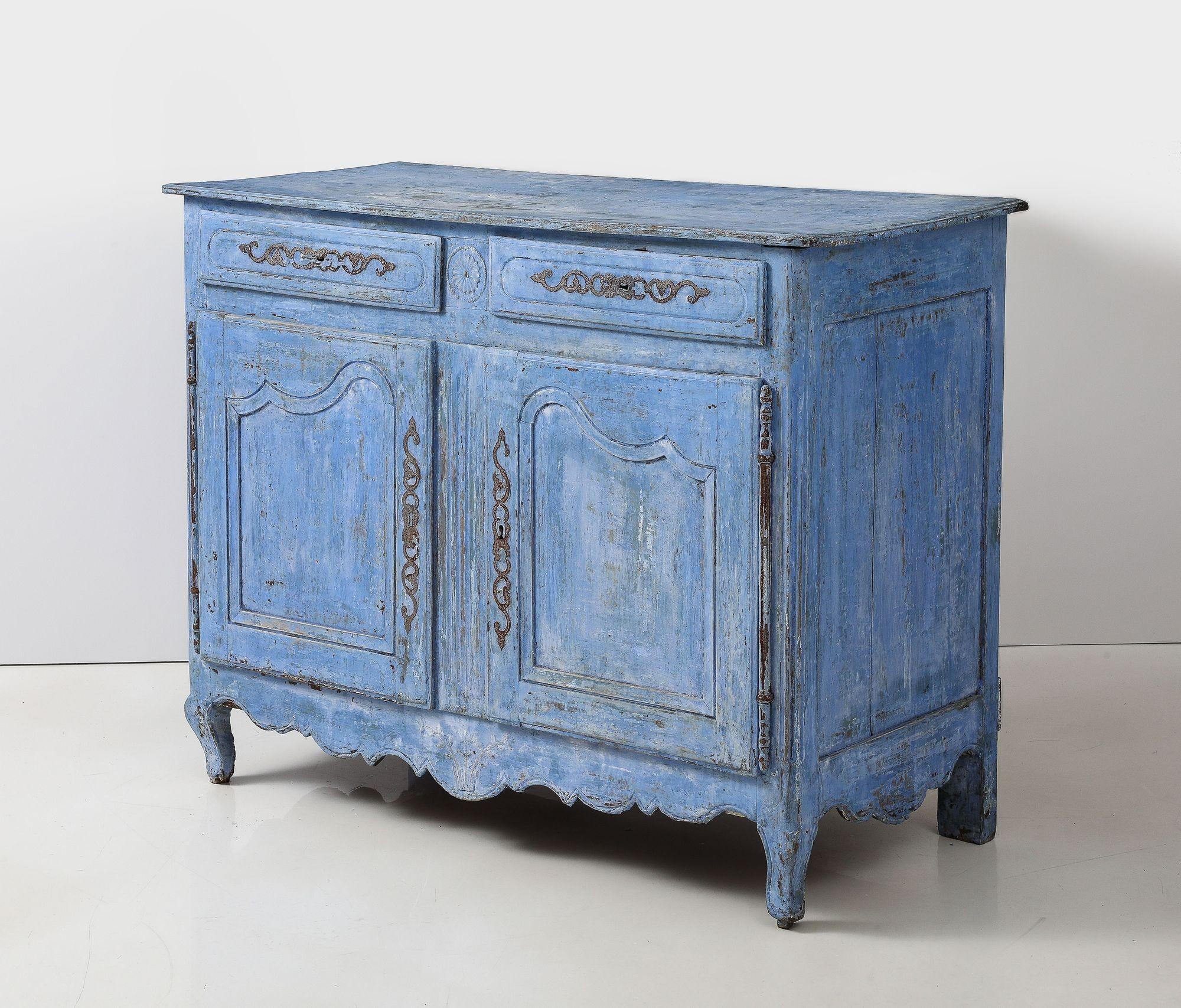 Ce buffet français du XIXe siècle met en valeur l'élégance du style provincial français Louis XIV. Il comporte deux tiroirs au-dessus d'un meuble à deux portes, orné de charnières en métal qui renforcent son charme rustique. La peinture bleu vif,