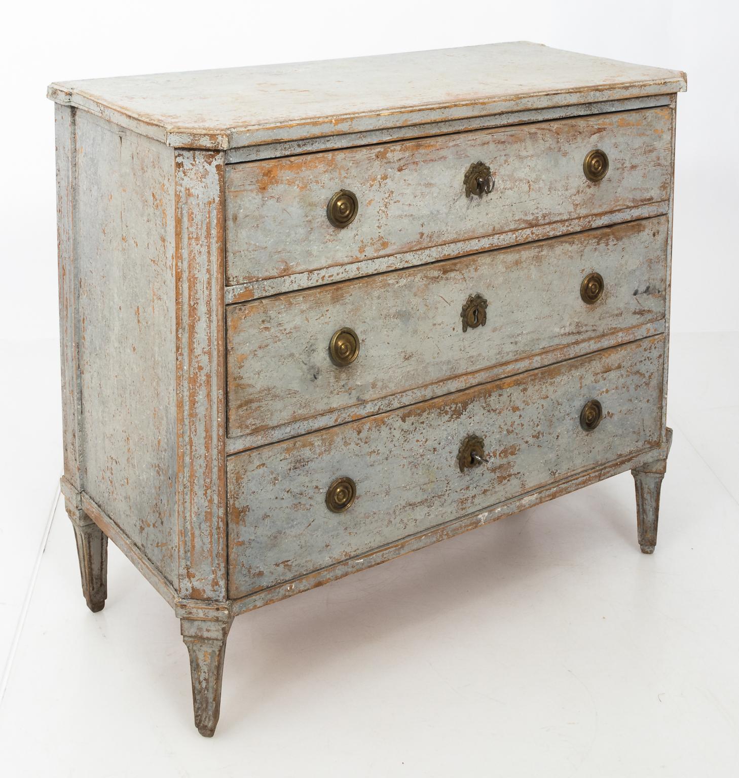 Blue painted Gustavian chest of drawers with classical elements of the period such as floral brass escutcheon and turned legs, circa 1790. The historic blue paint shows some restoration and has original patina.
              