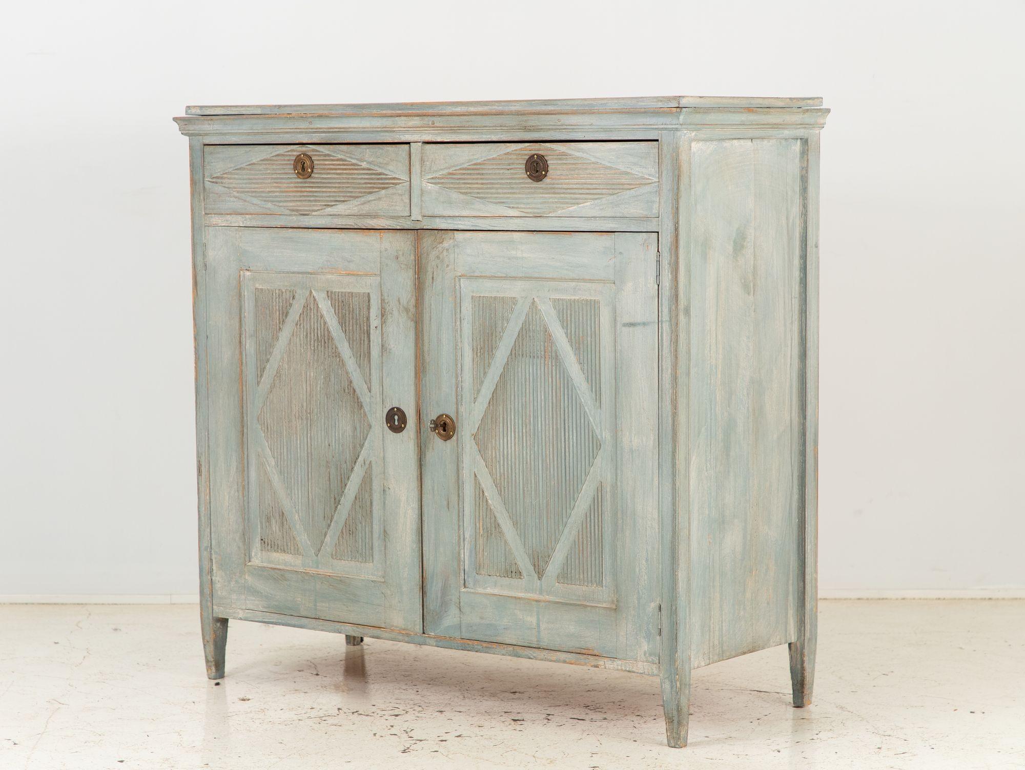 Emanating the grace of late 19th-century Gustavian style, this captivating blue-painted buffet evokes a sense of timeless sophistication. The buffet's two doors over a two-door cabinet configuration offers a harmonious balance of form and function.