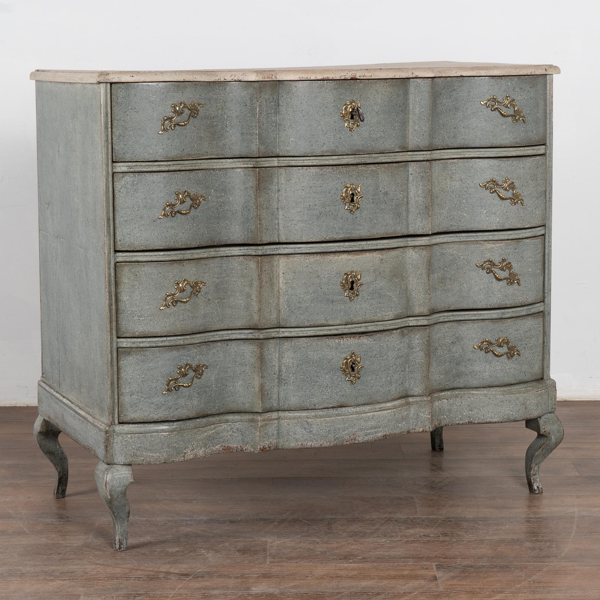 This large antique rococo oak chest of four drawers features a serpentine front, brass hardware pulls and rests on cabriolet feet.
It has been given an exceptional new professional blue layered painted finish with mottled elements of teal, steel