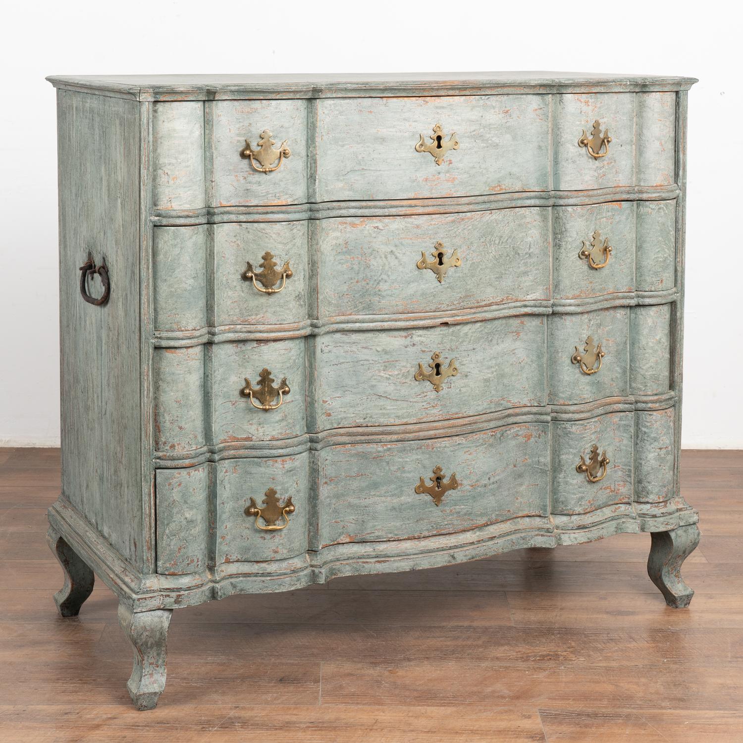 This large antique rococo oak chest of drawers features a serpentine front, handsome brass hardware pulls and rests on cabriolet feet.
It has been given an exceptional new professional seafoam blue/green layered painted finish and has been lightly