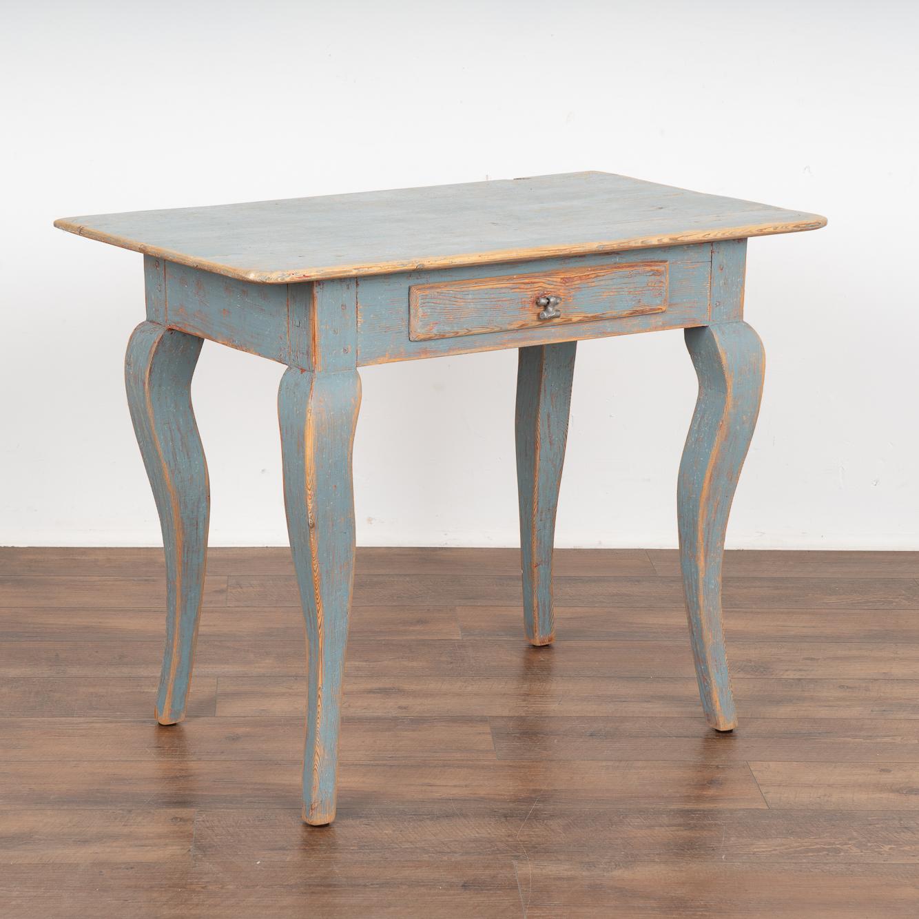 The curved cabriolet legs add a charming touch to this pine side table with single drawer from the Swedish countryside.
The newer, professionally applied blue painted finish has been lightly distressed revealing the natural pine and a trace of old