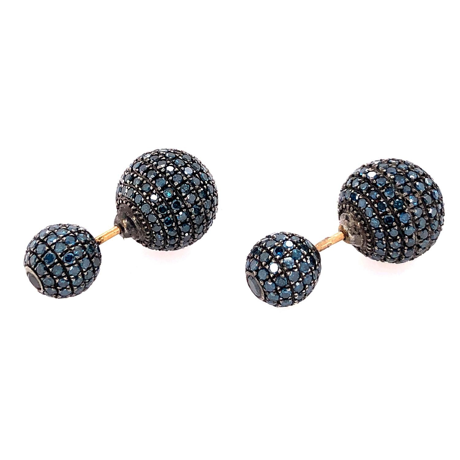 These blue pave diamond ball earrings are made of 18k gold and silver, combining two precious metals in a stunning and unique design. The earrings feature a round ball shape, encrusted with sparkling blue diamonds in a pave setting. The diamonds add