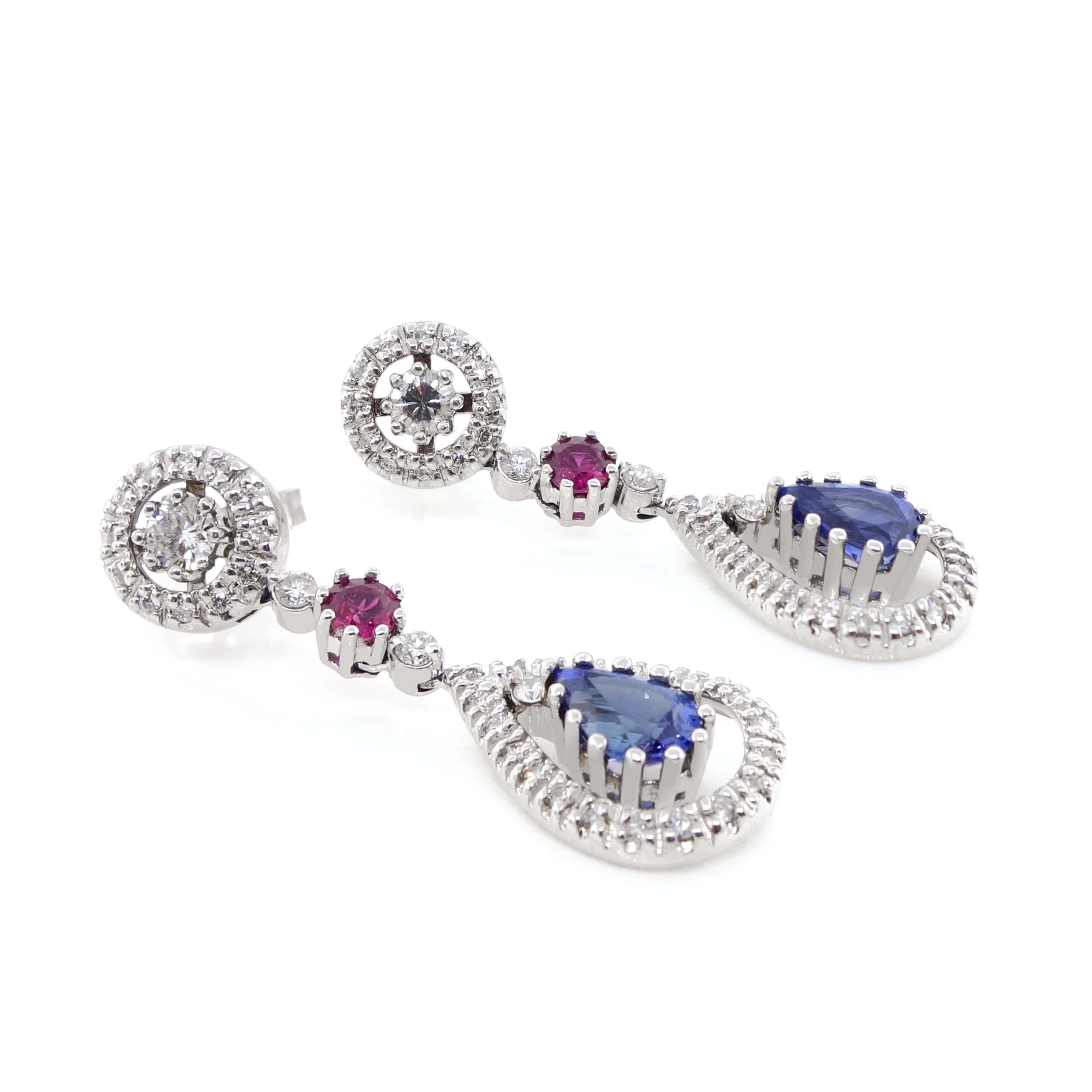 Diamond Earrings containing 2 fine blue pear shape sapphires of about 2.06 carats, 2 round rubies of about 0.45 carats, 72 round brilliant cut diamonds of about 1.06 carats with a clarity of SI and color G. All stones are set in 14k white gold. The