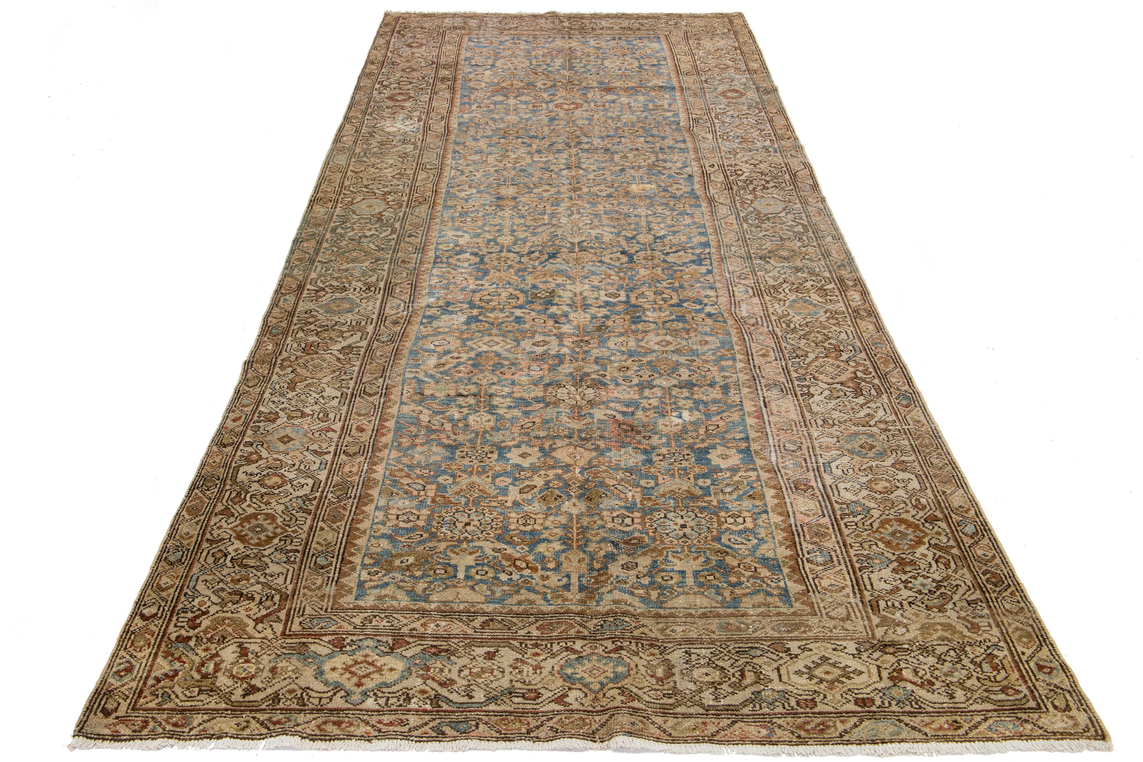 Dieser antike persische Malayer-Teppich ist aus Wolle handgeknüpft. Das Design zeigt ein wunderschönes Blau als Basis, das mit braunen, beigen und pfirsichfarbenen Akzenten in einem atemberaubenden, detaillierten Blumenmuster aufgewertet