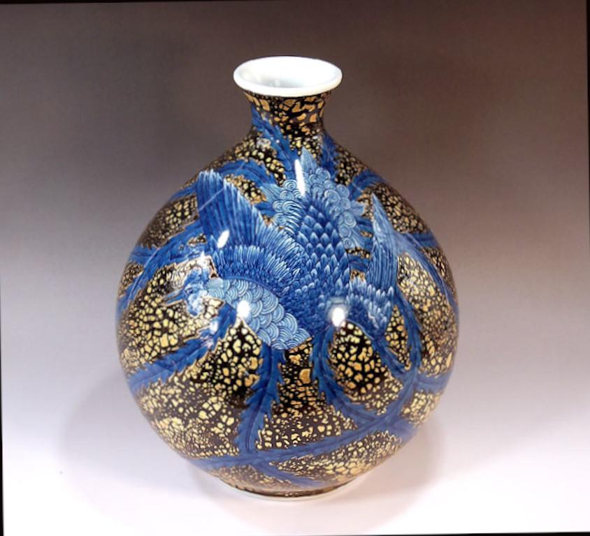 Japanese contemporary decorative porcelain vase, extremely intricately hand painted in various black and shades of vivid blue set against a beautifully shaped ovoid porcelain body in a stunning cracked gold, to create a mesmerizing surface. It is