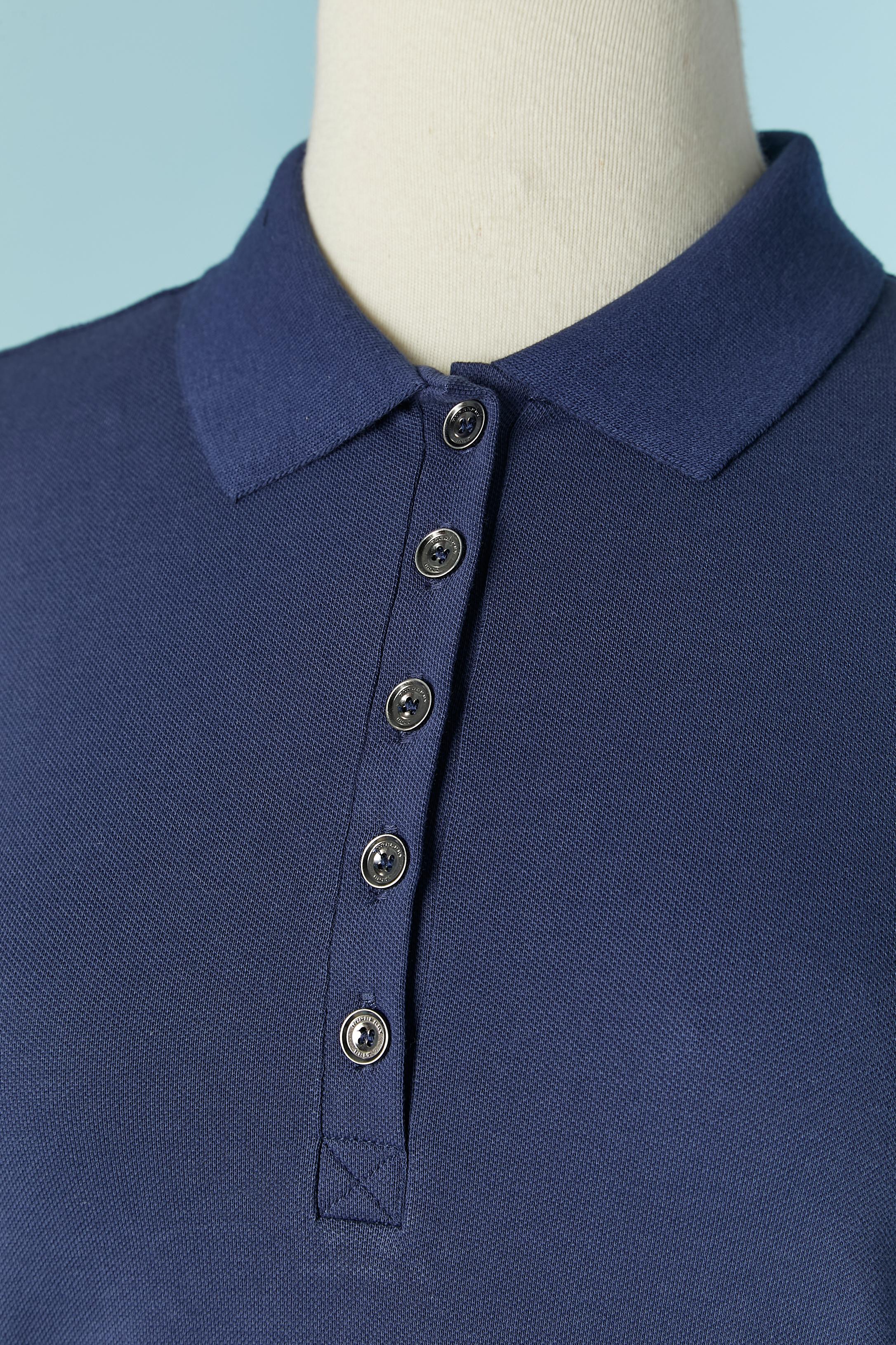 Blaues Poloshirt . Zusammensetzung des Stoffes: 98% Baumwolle, 2% Elastan. Prüfen Sie das Muster an der Innenseite des Ärmelrands.
Markenknopf und Knopflochverschluss auf der oberen Vorderseite. Eine zusätzliche Taste ist vorhanden.
GRÖSSE S 