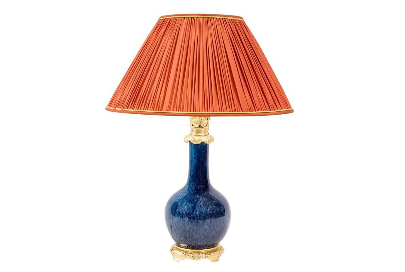 Bottle-shaped lamp in blue iridescent porcelain, imitating goldstone. Chiseled and gilt bronze mount with a circular openwork base and an upper part with chiseled vine branches and leaves.
Brand new and functional electrical system.
Made in the late