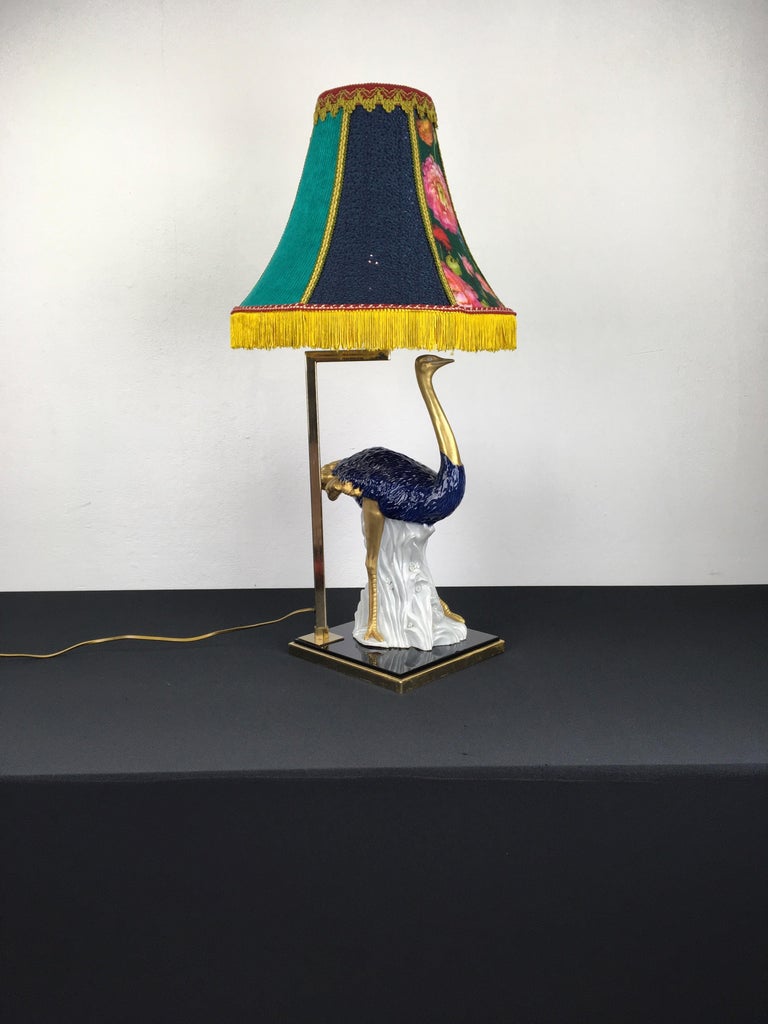 Blue porcelain table lamp in the shape of an ostrich bird. 
This exceptional and stylish vintage table Lamp has a cobalt blue with gold painted porcelain ostrich which is 
mounted on a facet cut cobalt colored glass. The bird is very detailed, has