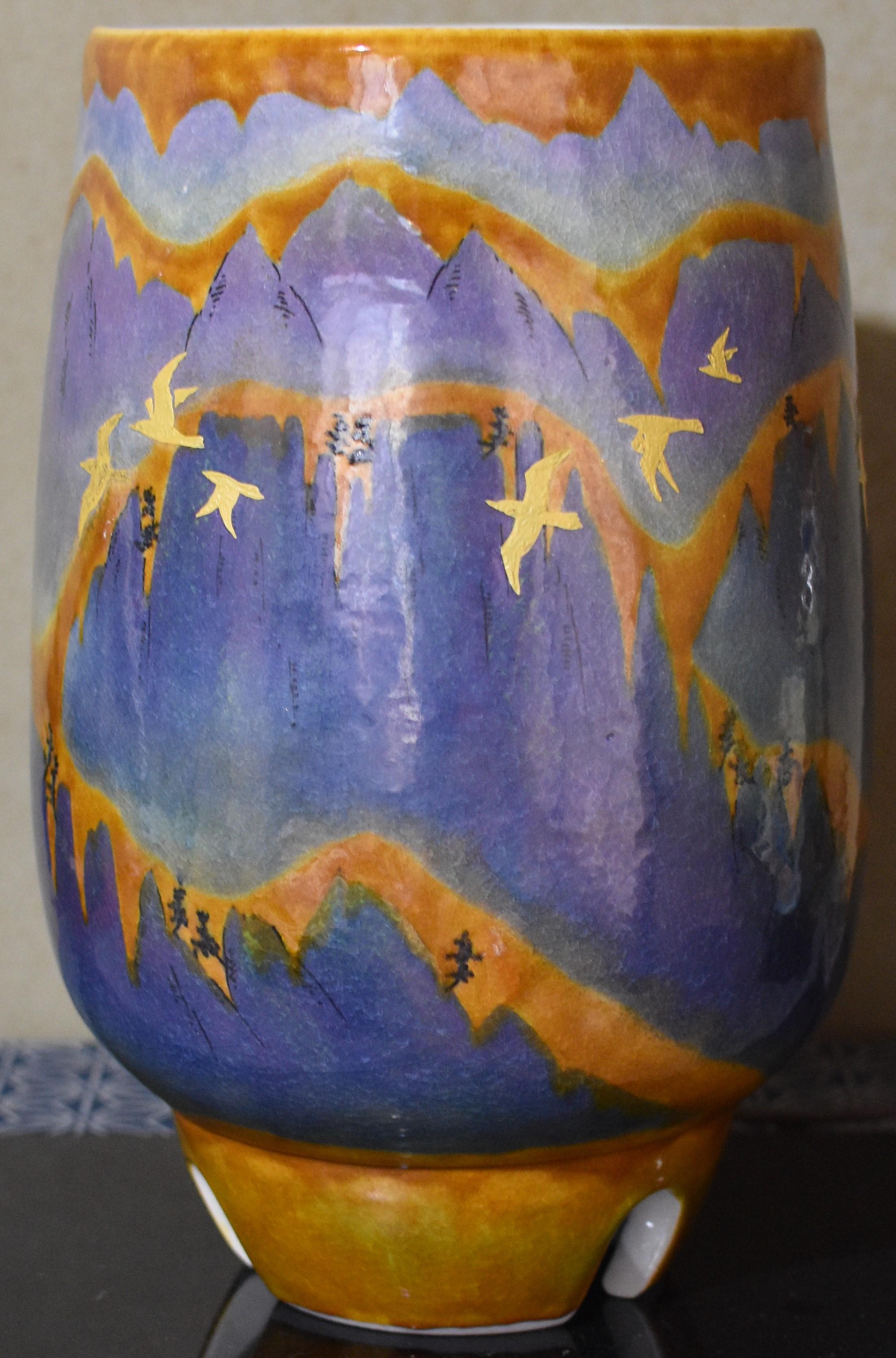 Grand vase contemporain époustouflant en porcelaine décorative japonaise sur pied, peint à la main de manière complexe en orange vif, jaune et nuances étonnantes de la signature de l'artiste, le violet, sur un corps cylindrique de forme étonnante.
