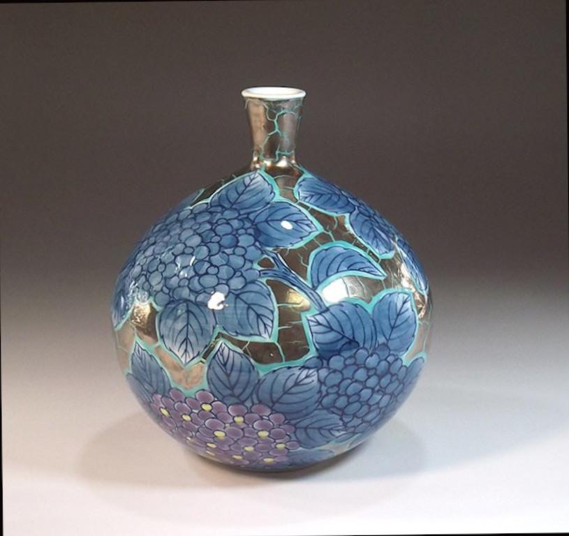 Contemporary Japanese decorative porcelain vase, hand painted in blue, purple and yellow set against a beautiful bottle shaped porcelain body in platinum. This is the work of highly acclaimed master porcelain artist in traditional patterns of the