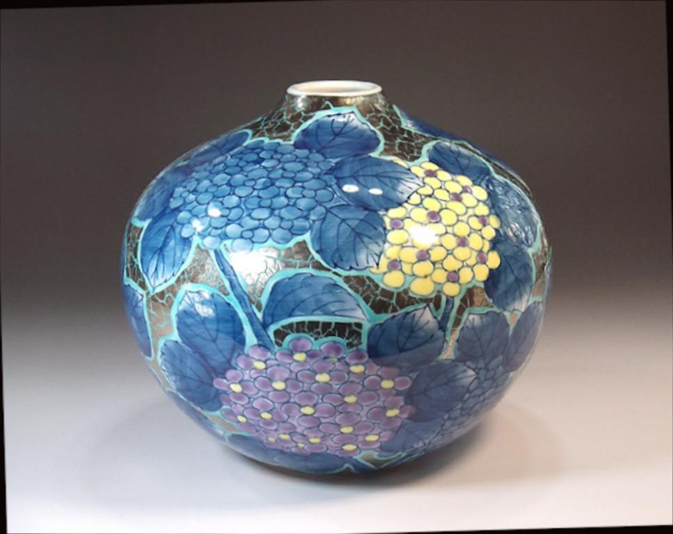 Contemporary Japanese decorative porcelain vase, hand painted in blue, purple and yellow set against a beautifully shaped ovoid porcelain body in platinum. This piece is by highly acclaimed master porcelain artist in traditional patterns of the