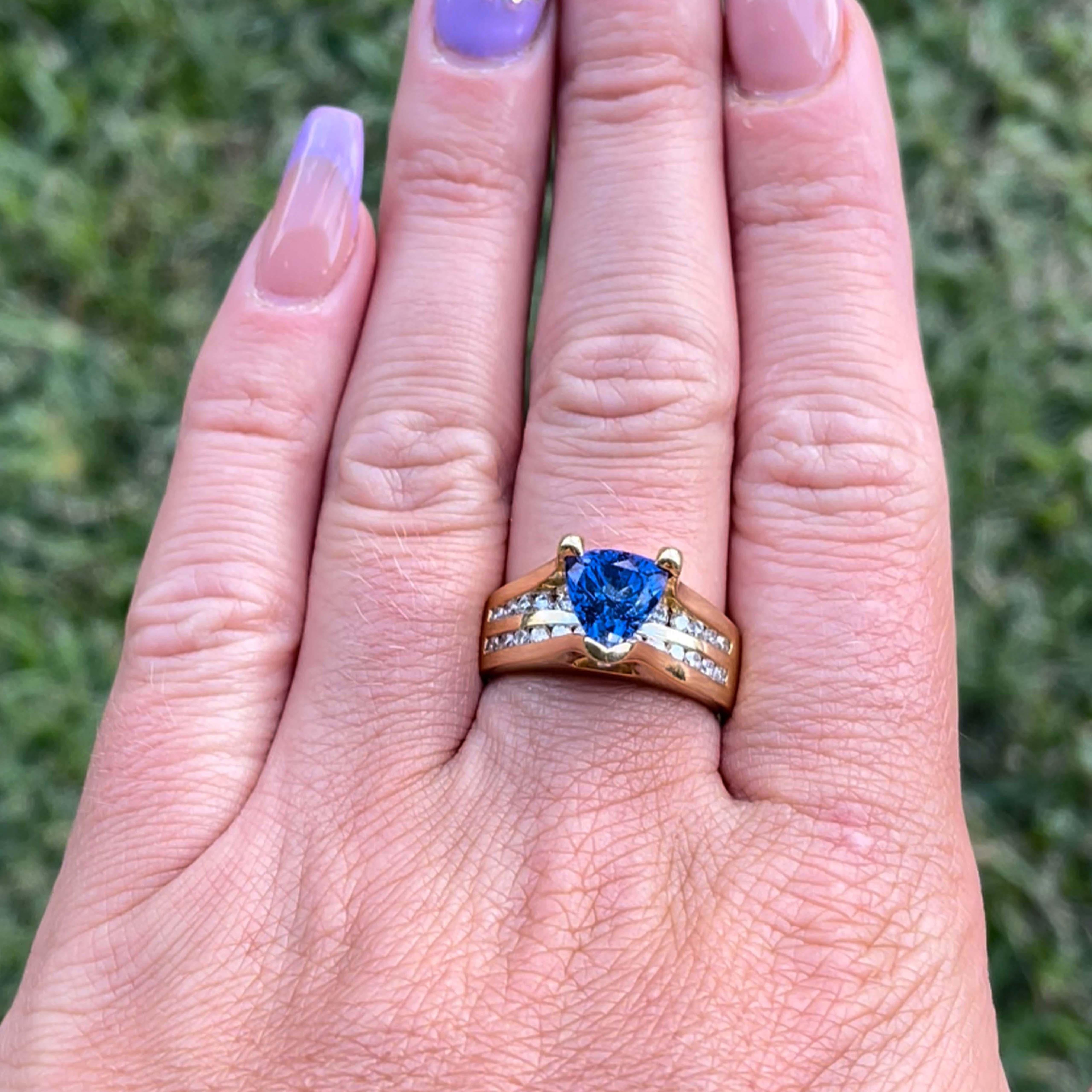 Blue Purple Tanzanite and Diamond Ring-18k Yellow Gold. Featuring a deep bluish purple color, trilliant shape Tanzanite, measuring approximately 8.50mm x 7.86mm x 6.20mm with an estimated total weight of 2.10 carats. The ring is set with 26 round