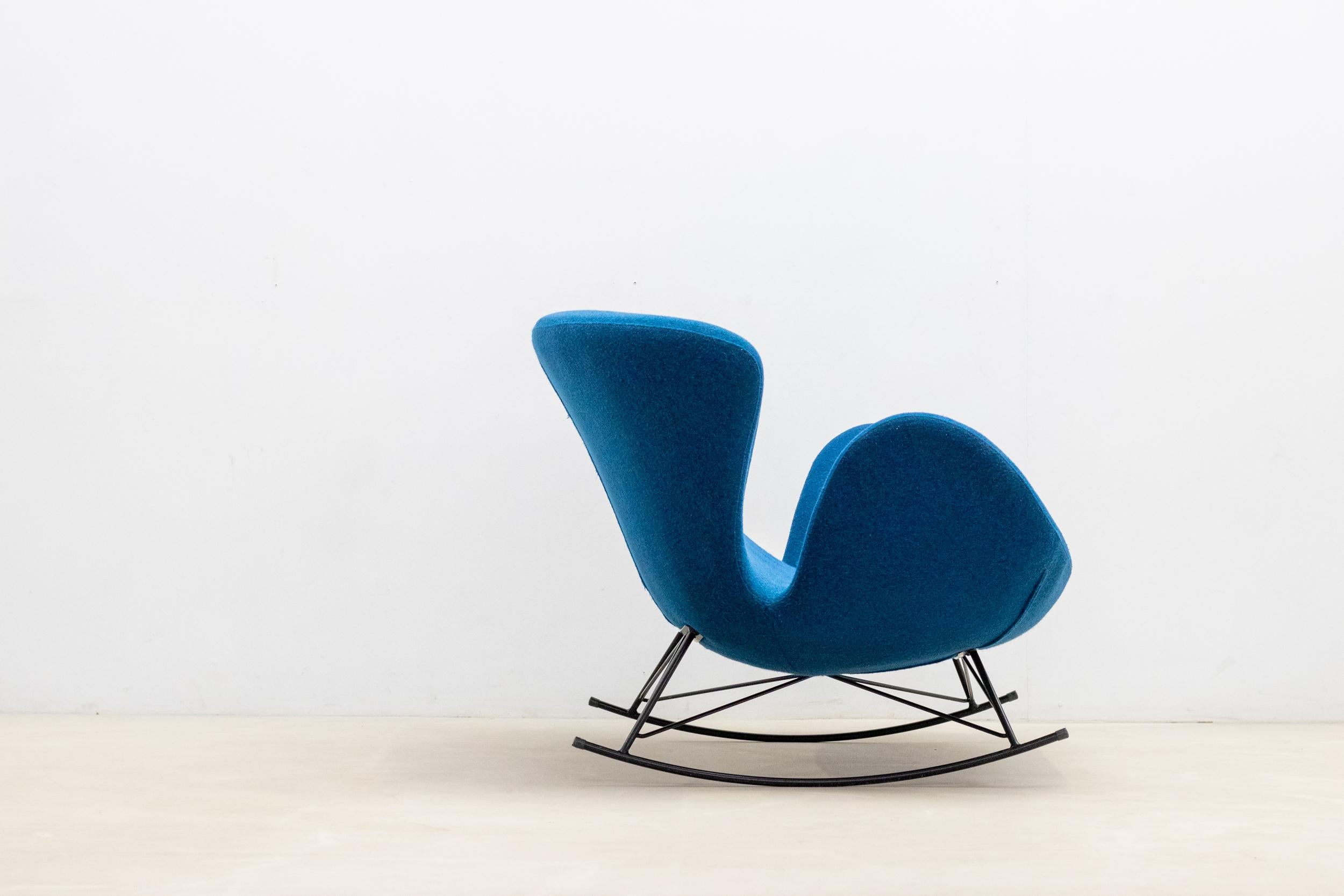 Un fauteuil à bascule 2 places dans le style d'Arne Jacobsen est un meuble confortable conçu pour offrir une expérience d'assise douillette. 

Il vous permet de vous balancer doucement d'avant en arrière pour une expérience apaisante et calmante.
Le