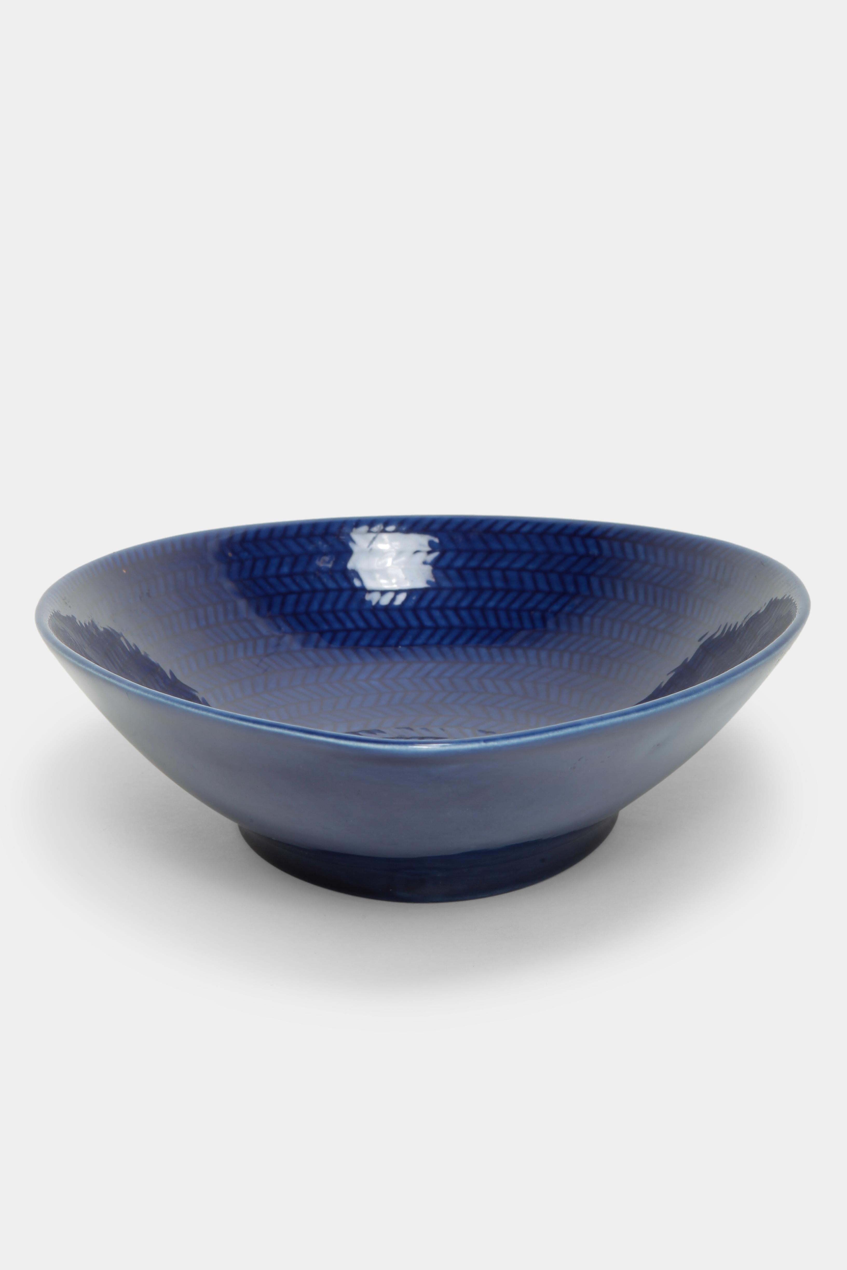 Ceramic bowl by Hertha Bengtson designed for the Swedish manufacturer Rörstrand in the 1950s. Belongs to the Blå Eld (blue fire) series. The elongated bowl has a deep blue color with an intricate pattern on the inside.
