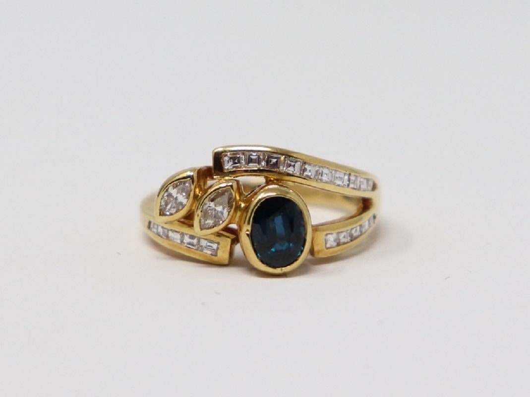18 Karat yellow gold ring with central 0.70 Carat blue sapphire. The sapphire is surrounded by about 0.90 Carat carrè cut diamonds and marquise cut diamonds. 
Total weight:  6.10 g.
New contemporary jewelry. Produced in the famous Italian city of