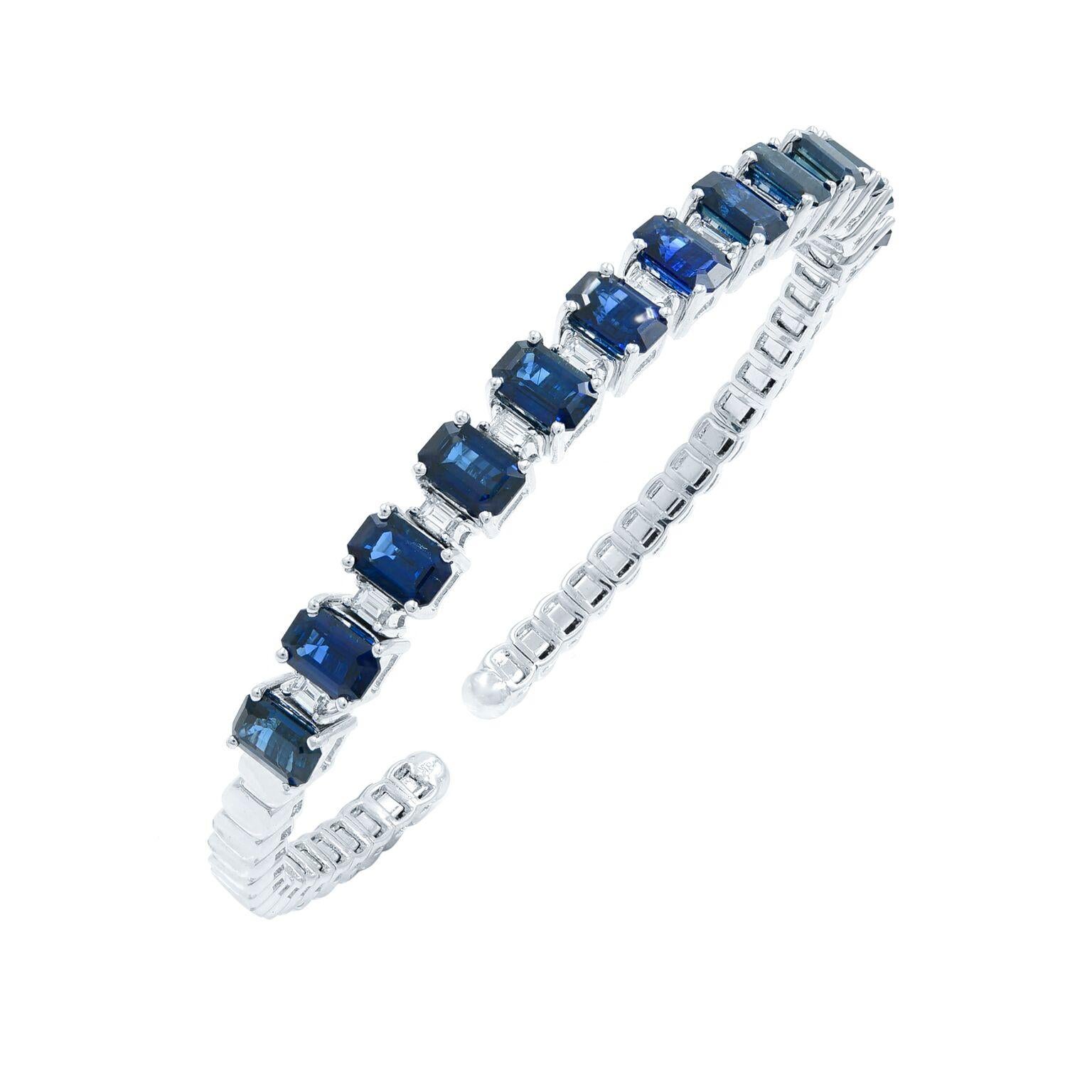 This stunning and exemplary bangle bracelet is crafted in 18K white gold. Starring prong set radiant rich blue emerald cut sapphires weighing 10.20 carats and baguette cut diamonds weighing 1.20 carats. Length: 7.25 inches. Width: 3.7mm. Total