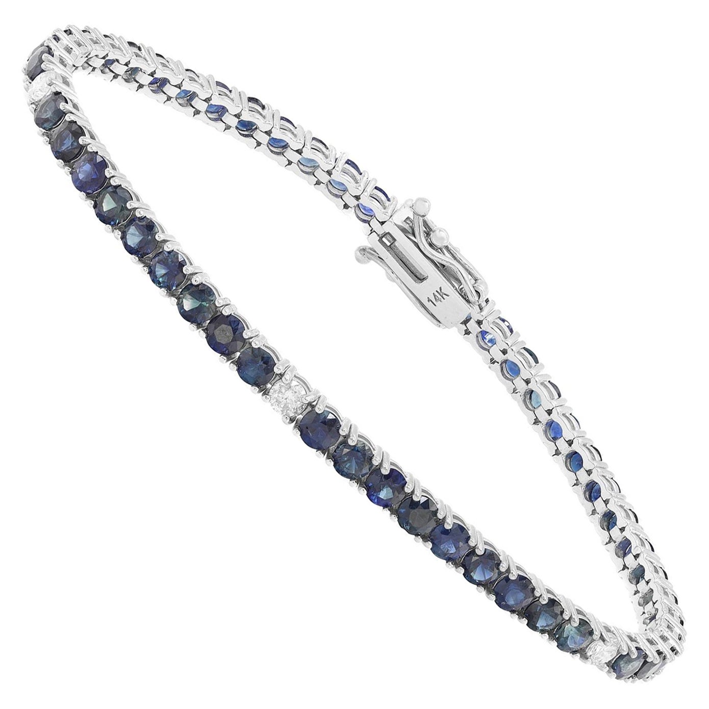 Esta pulsera tenis de bella factura presenta zafiros azules de talla redonda y diamantes incrustados en engaste de cuatro garras. Elaborada en oro blanco de 14 quilates. Peso total del diamante: 0,32 quilates. Calidad del diamante: color H y
