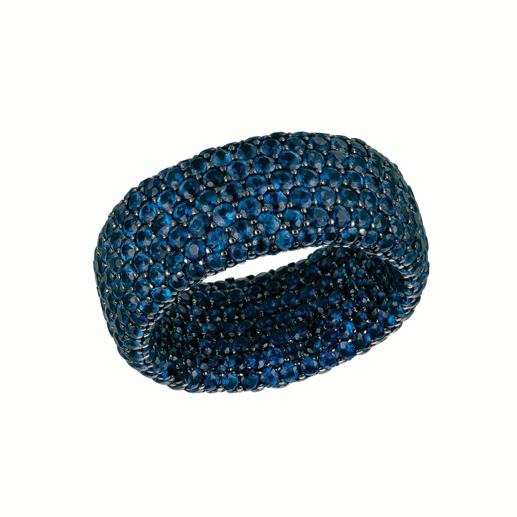 This unique design truly covers your finger in perfectly matched blue sapphires. The 18 karat gold has been Rhodium plated for an even more dramatic look. Named the 