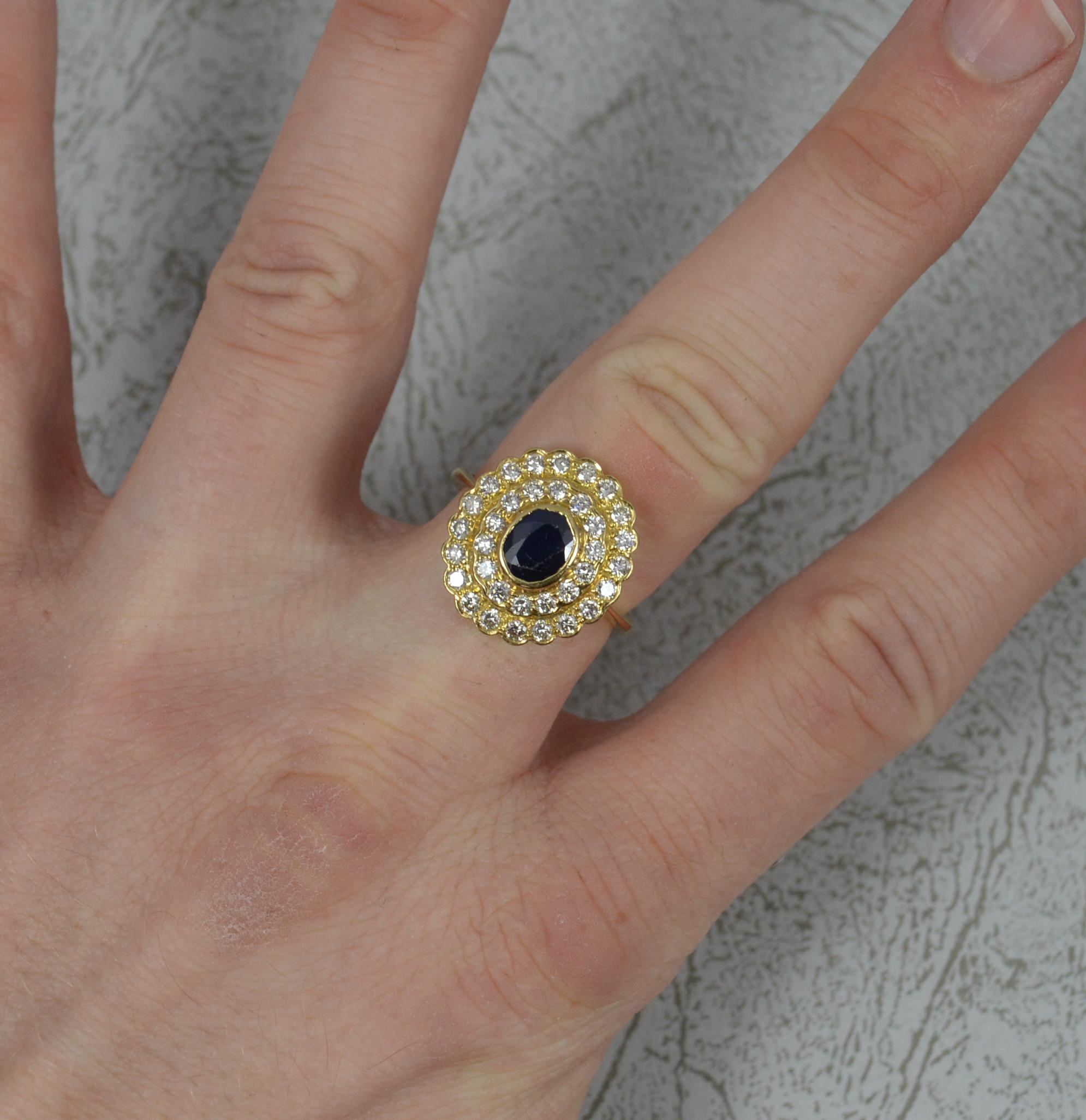 A fantastic Sapphire and Diamond ring.
Solid 18 carat yellow gold shank and head.
Designed with a natural oval cut blue sapphire to centre in full bezel setting. 5.4mm x 6.6mm. Surrounded by two full rows of round brilliant cut diamonds, Vs clarity.