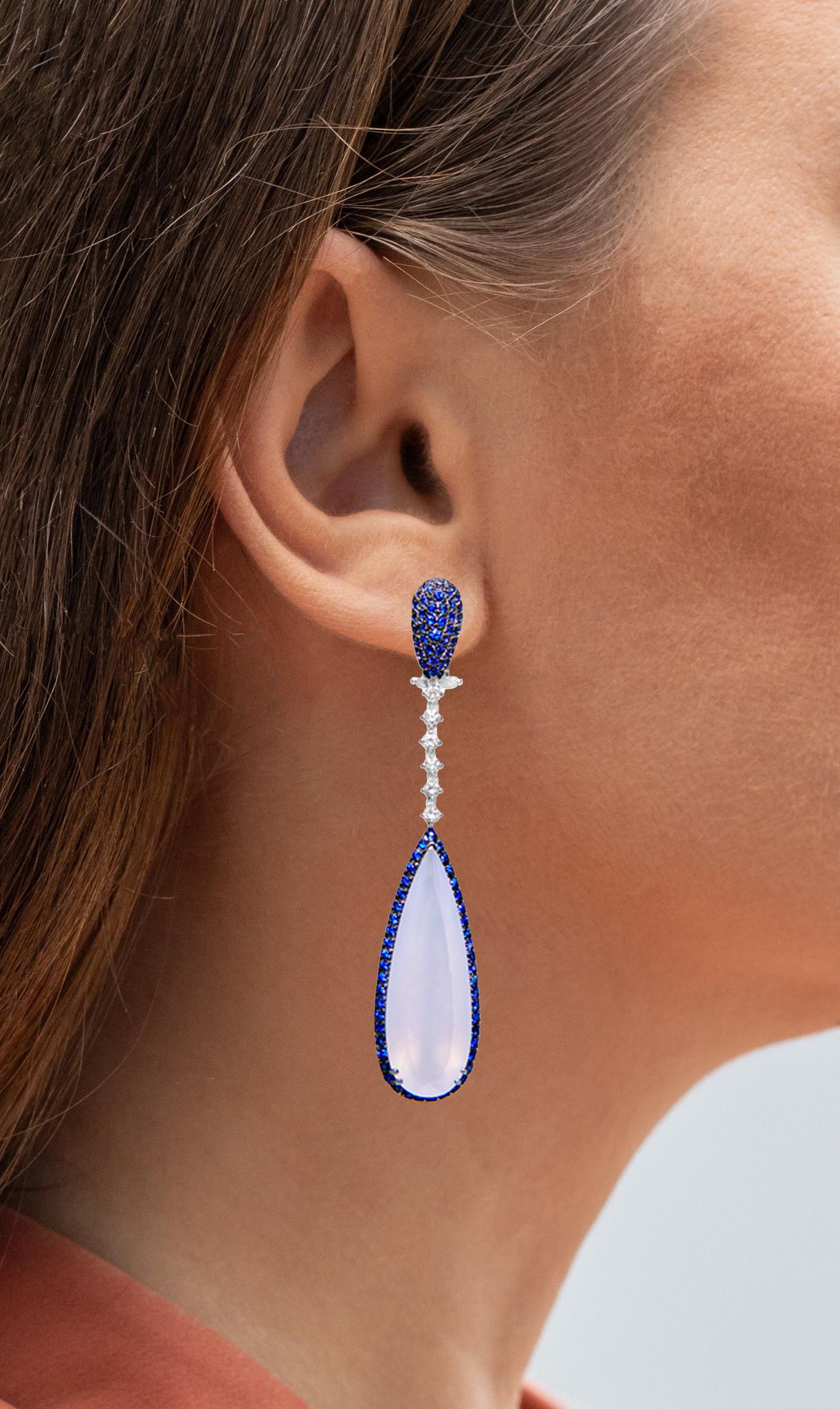 It comes with the Gemological Appraisal by GIA GG/AJP
All Gemstones are Natural
2 Chalcedonies = 30.50 Carats
210 Blue Sapphires = 1.56 Carats
12 Diamonds = 0.42 Carats
Metal: 18K White Gold
Dimensions: 67 x 13.7 mm
