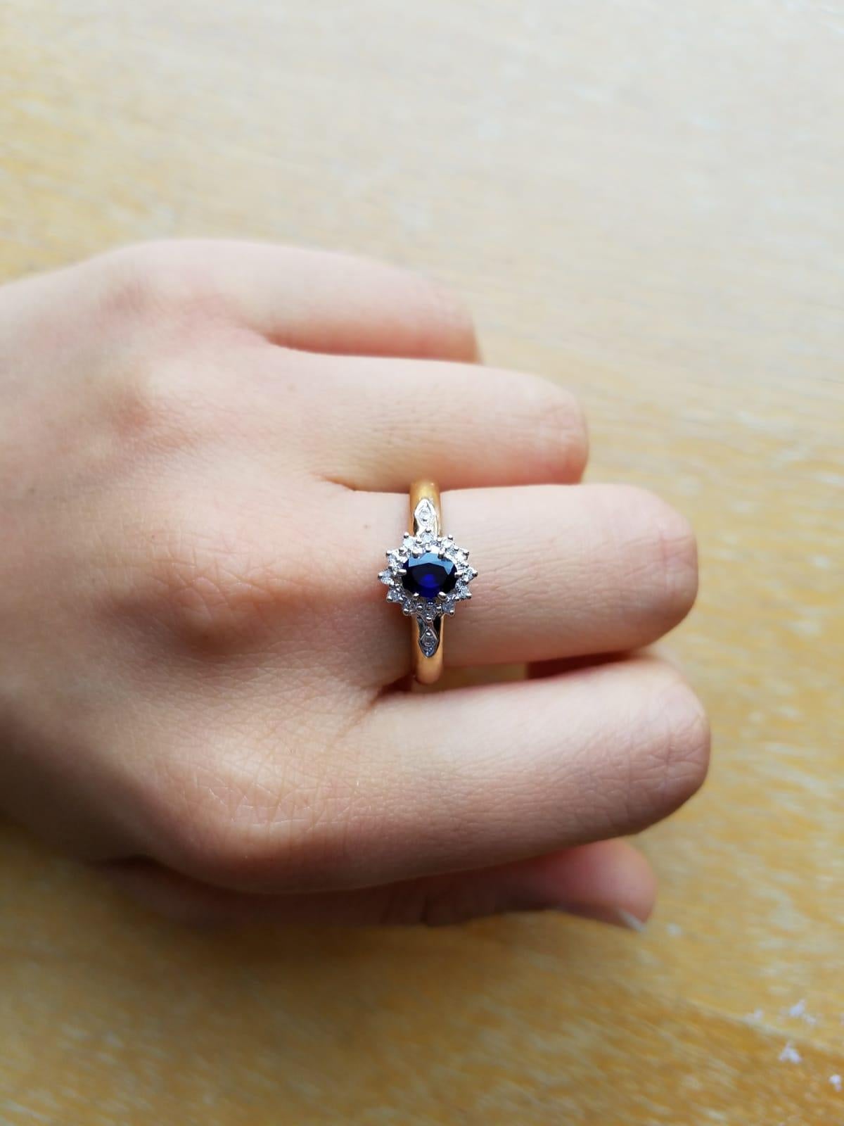 An elegant and simple ring using a lustrous Blue Sapphire centre stone surrounded by brilliant cut white Diamonds, all set in 14K white and yellow gold. Currently a ring size US 6.5, but we can resize the ring for you without additional cost.