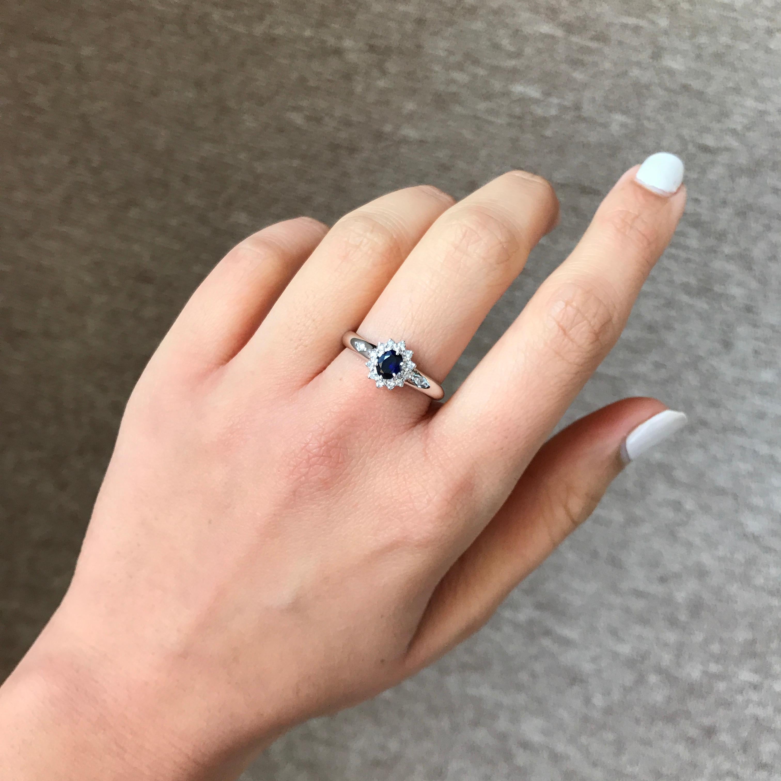 An elegant and simple ring using a lustrous Blue Sapphire centre stone surrounded by brilliant cut white Diamonds, all set in 14K white gold. Currently a ring size US 6.5, but we can resize the ring for you without additional cost.