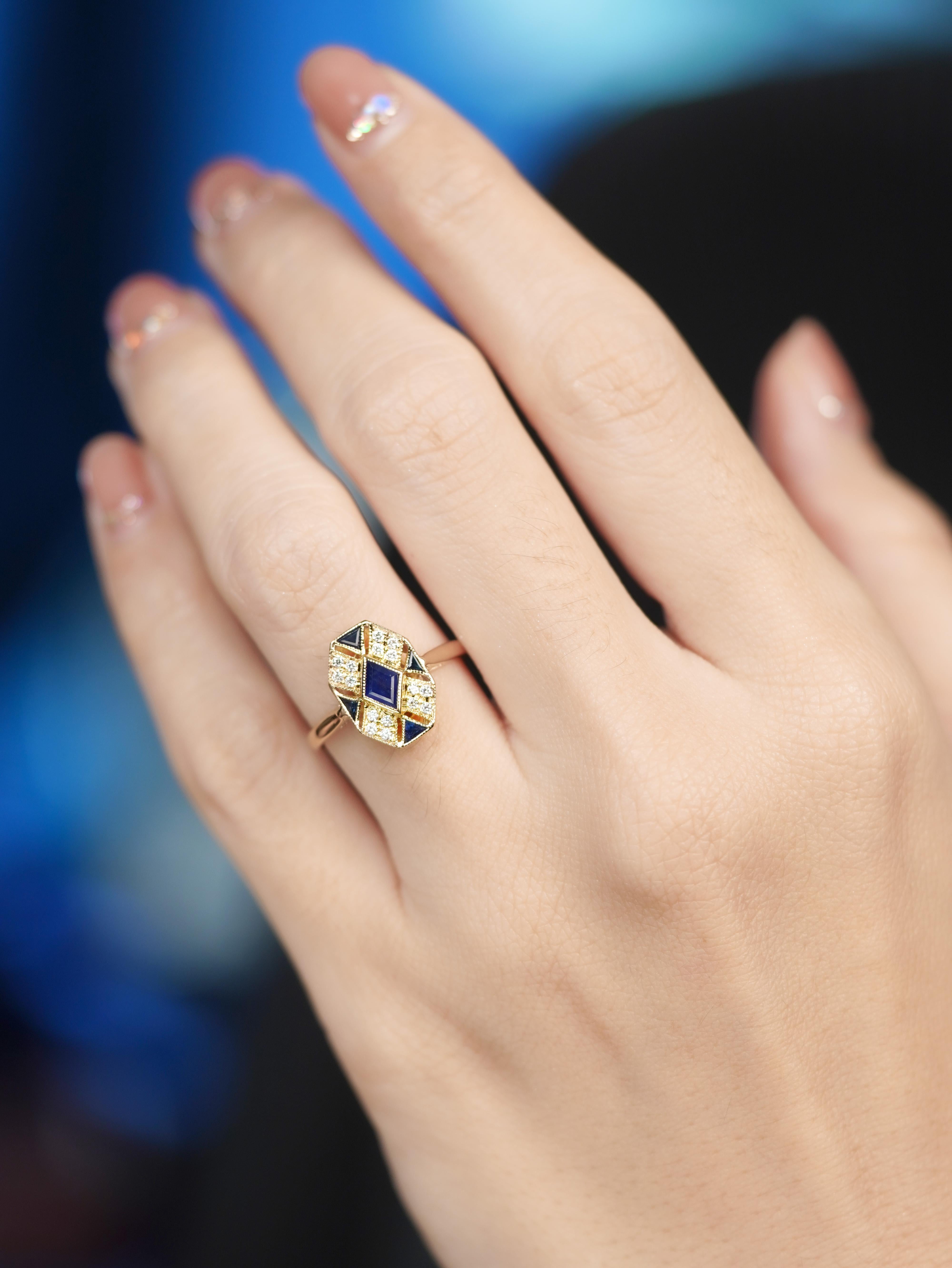 Eleganza audace dell'epoca Art Deco, questo anello a grappolo ha come cuore un profondo zaffiro blu. Altri zaffiri impreziosiscono ogni angolo, in alto, in basso, a sinistra e a destra, creando un sorprendente equilibrio geometrico. I brillanti