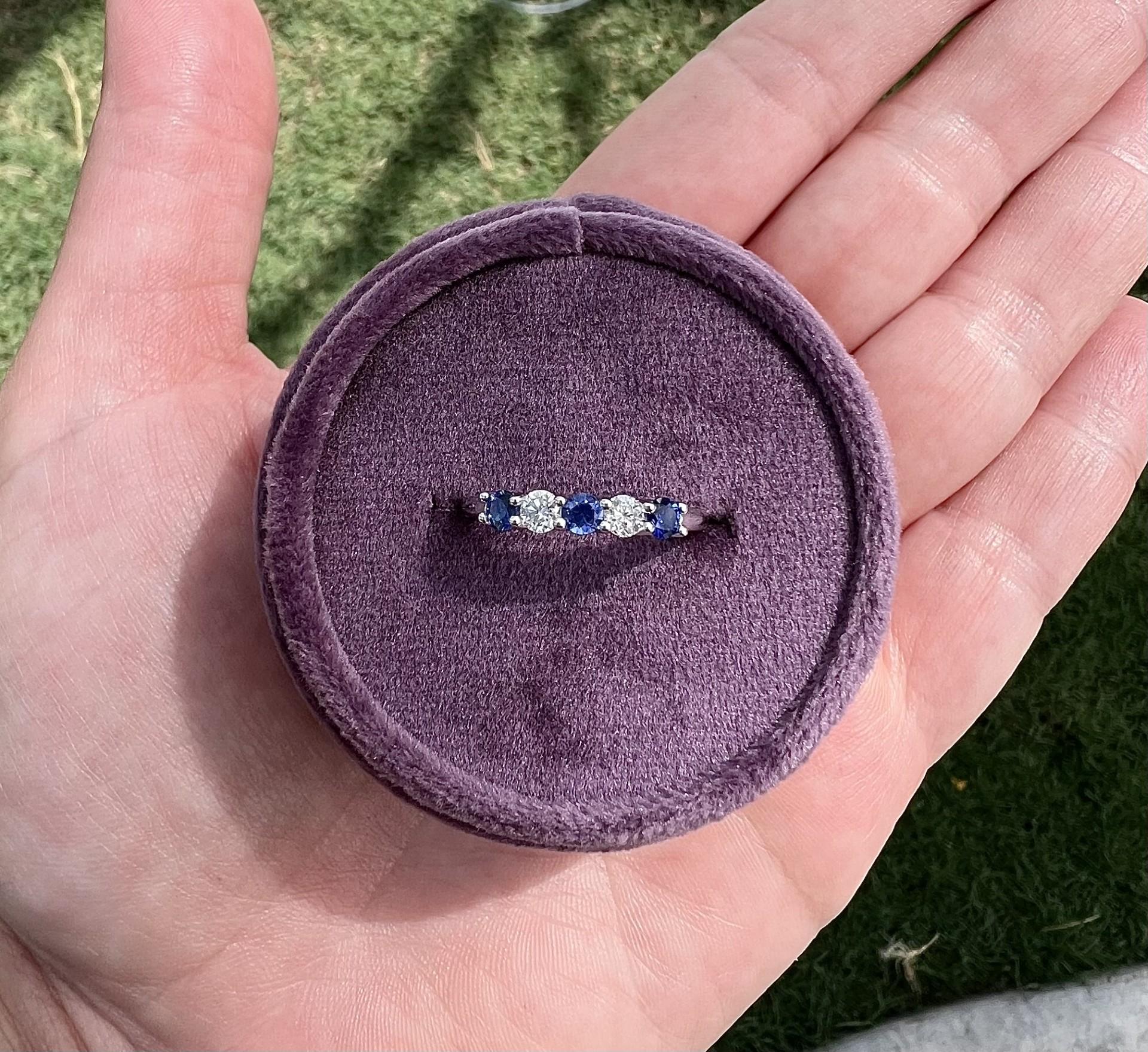This exquisite band showcases a harmonious blend of brilliance and elegance. Set in gleaming 14k white gold, the ring features alternating round-cut diamonds and rich blue sapphires, creating a stunning contrast. The diamonds, known for their