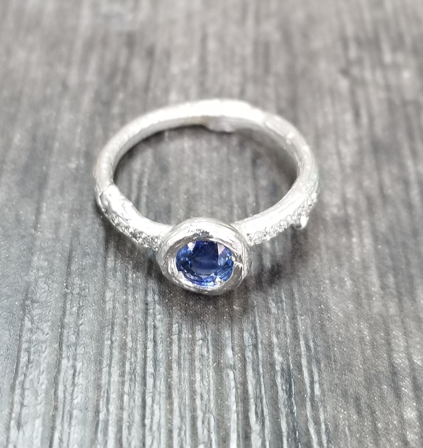 14k white gold Gresha signature bark ring with 5mm blue sapphire weighing .50pts. and 10 diamonds weighing .10pts. ring has been black rhodium.
*Available in 14k yellow, white or rose with green, yellow, orange, and pink sapphire. pick your