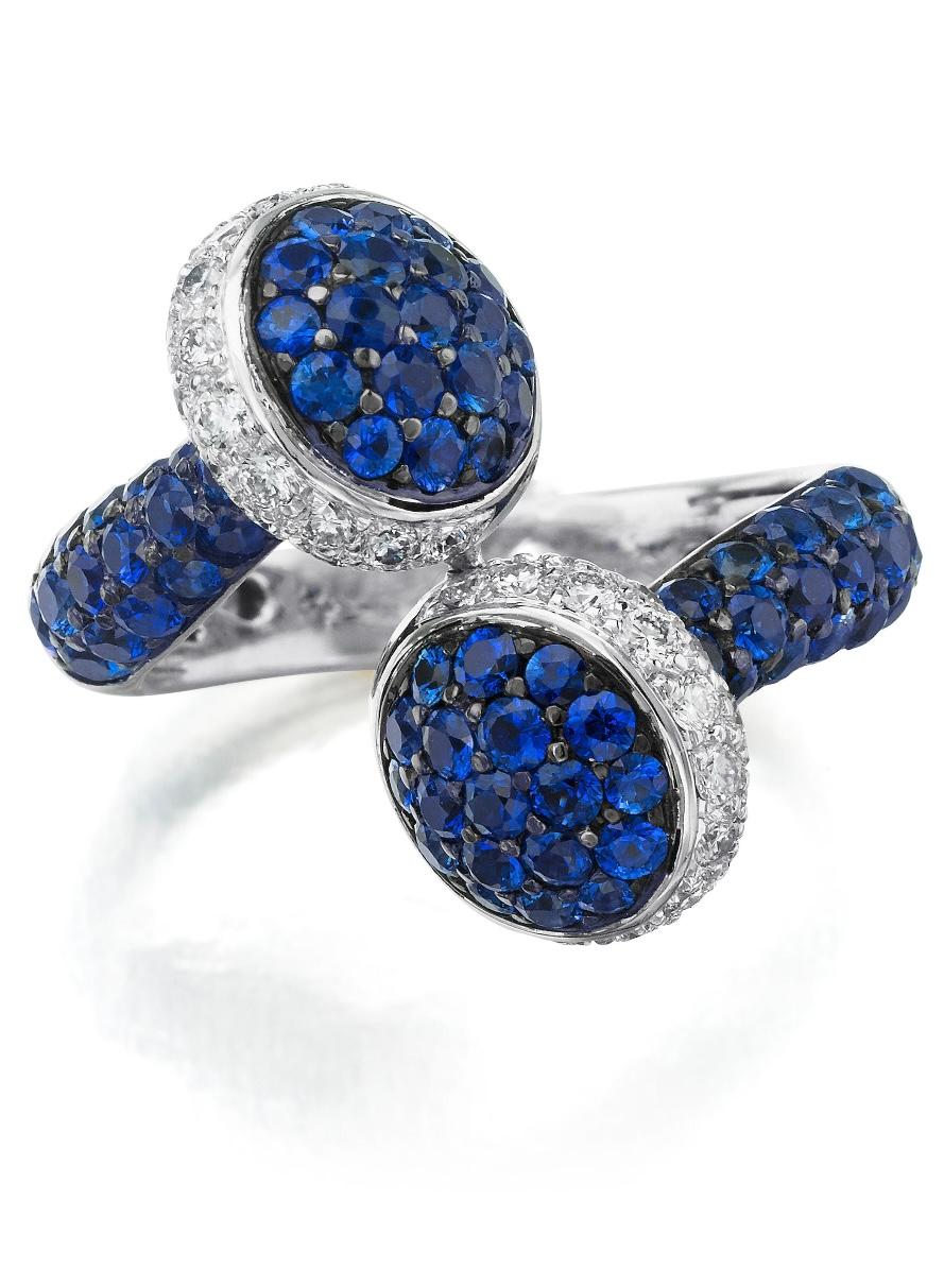 Unique and gorgeously made blue sapphire and diamond ring of bypass design,. with button terminals set with round brilliant cut diamonds. 
The details are as follows : 
Blue sapphire weight : 2.18 carats 
Diamond weight : 0.35 carat 
Metal : 18k