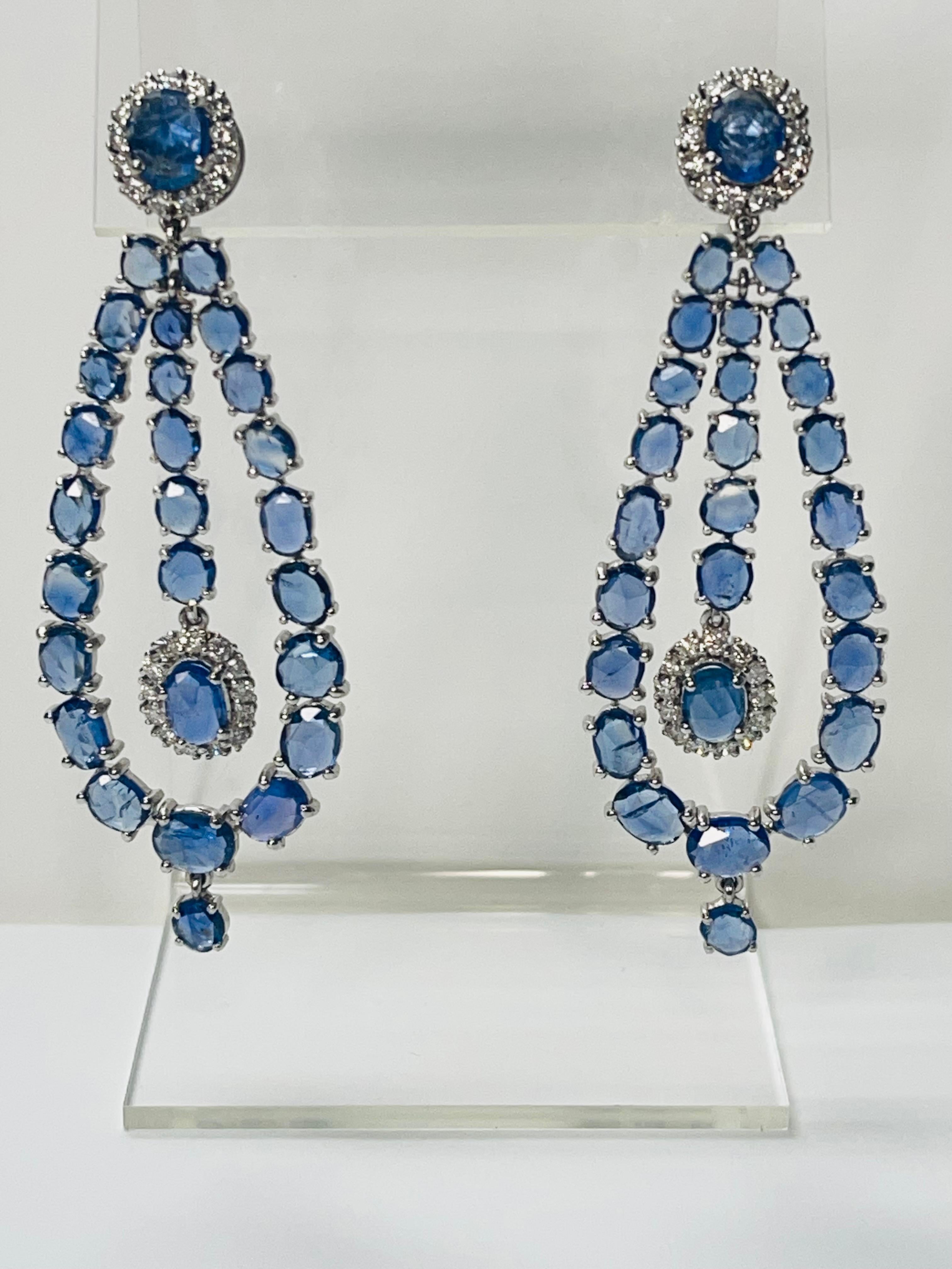 Questi splendidi orecchini a lampadario con zaffiri blu e diamanti sono realizzati a mano in oro bianco 18 carati. 

I dettagli sono i seguenti: 

Peso dello zaffiro blu: 15.25 carati 
Peso del diamante: 1,68 carati (colore G e purezza VS) 
Oro: