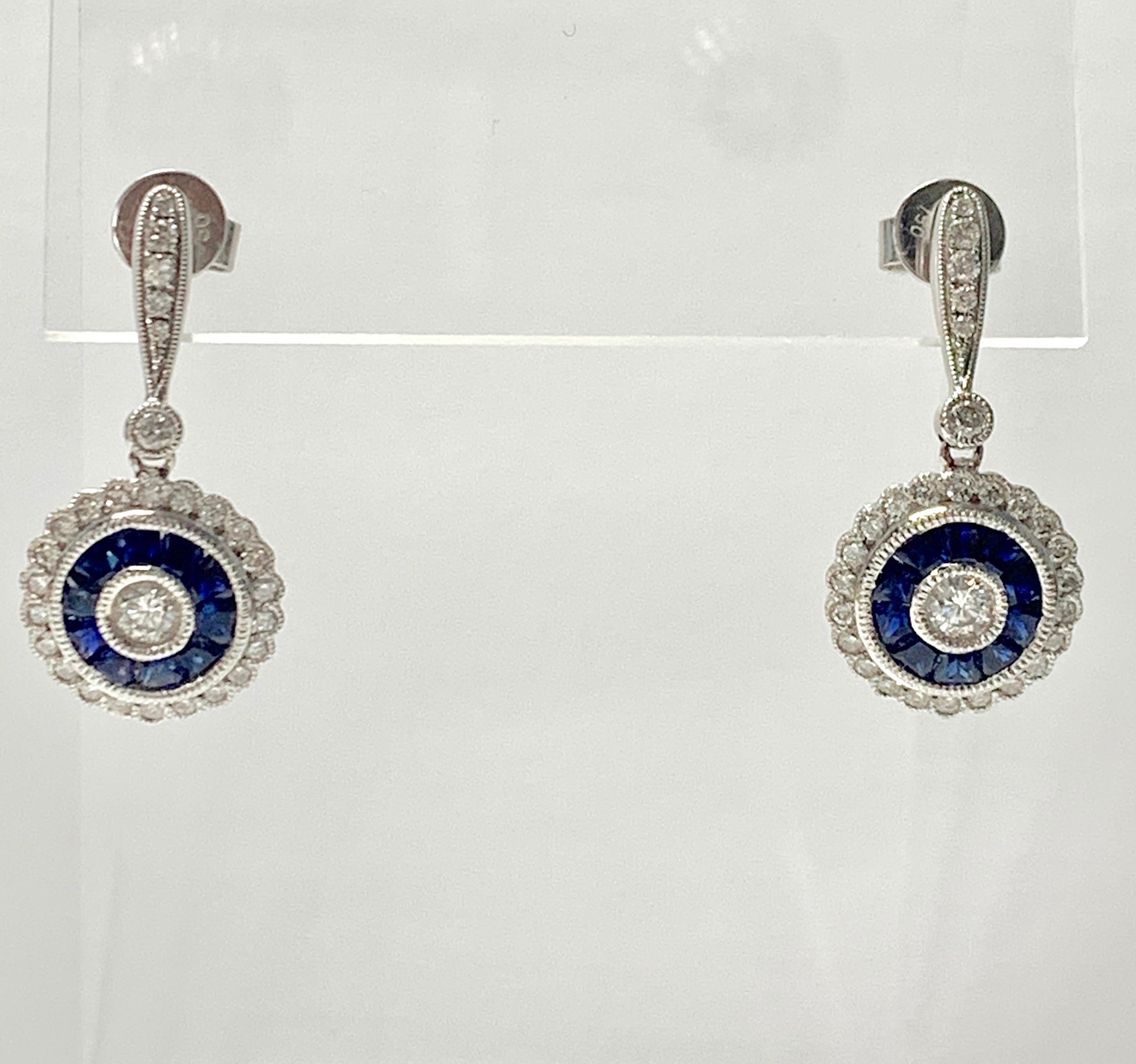 Blue sapphire and diamond dangle earrings handcrafted in platinum and 18k white gold. 
The details are as follows :
Diamond weight : 1 carat ( G color and VS2 ) 
Metal : platinum and 18k white gold 
Measurements : 1 inch long 
