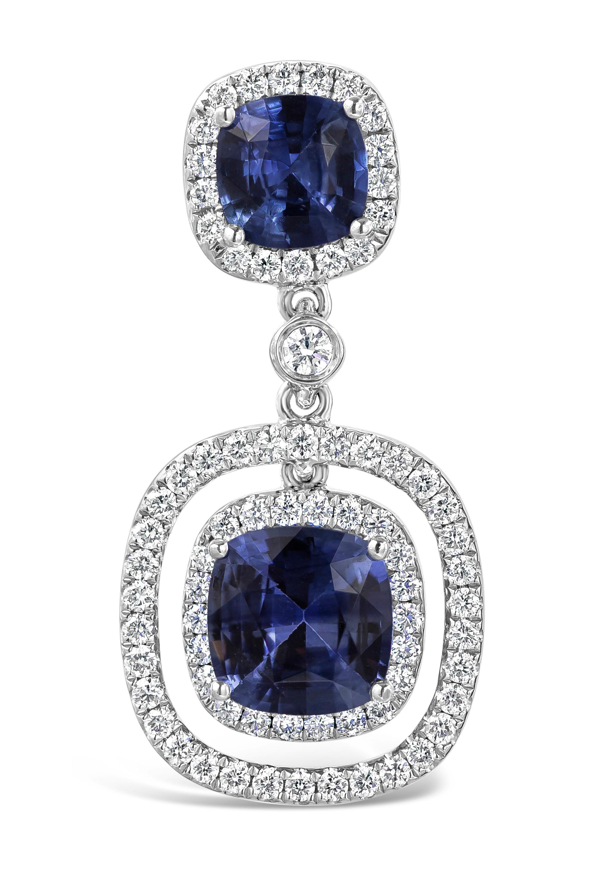 A stunning pair of gemstone dangle earrings showcasing four cushion cut blue sapphires set in four pong setting, surrounded by halo of brilliant round diamonds. Blue sapphires weighs 3.96 carats total and white diamonds weighs 0.76 carats total.