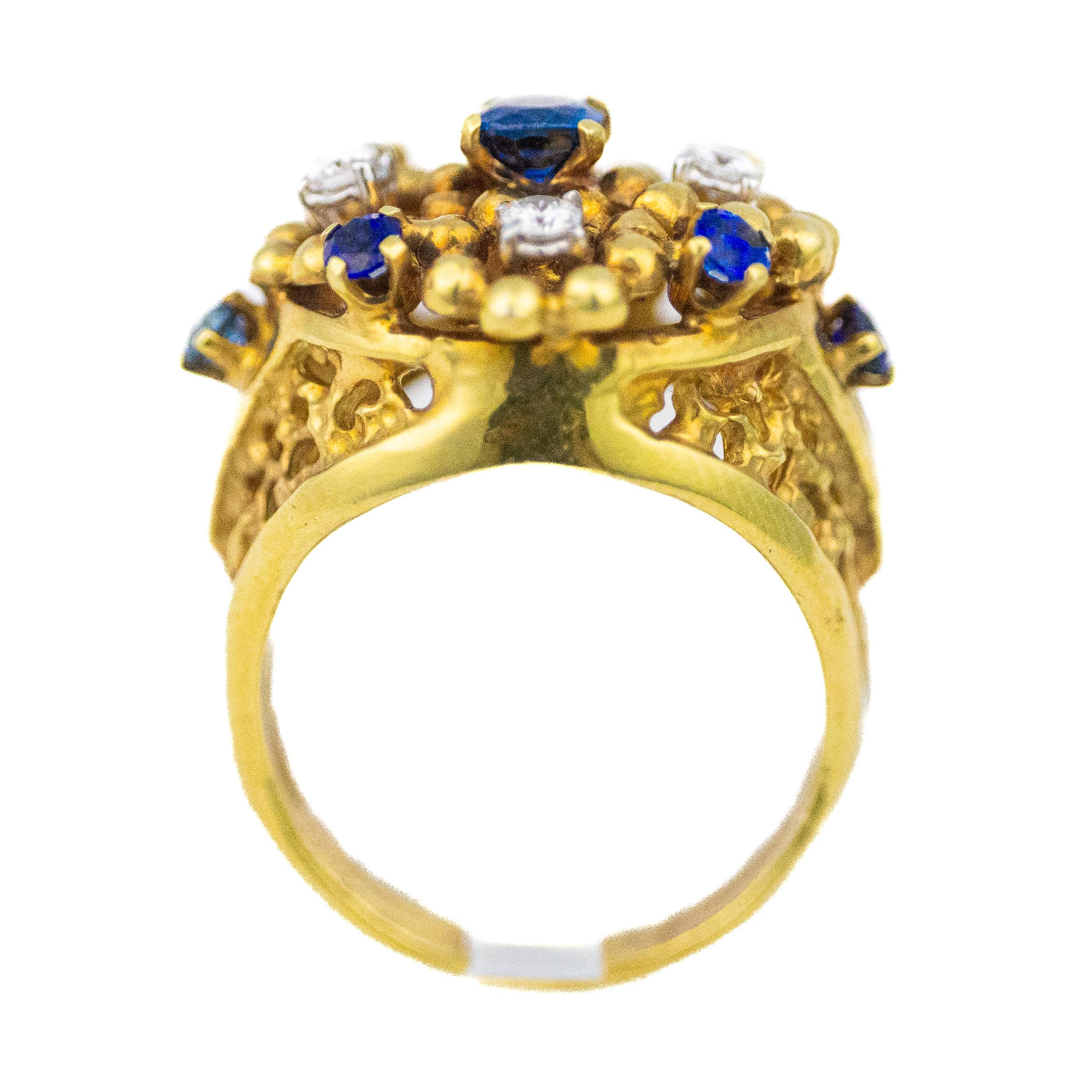 Blumenförmiger Ring mit blauem Saphir und Diamant

Beschreibung: Ein auffälliger Ring aus 14-karätigem Gelbgold mit einem runden Saphir in der Mitte, umgeben von abwechselnd angeordneten Saphiren und Diamanten im Brillantschliff in einem erhabenen,